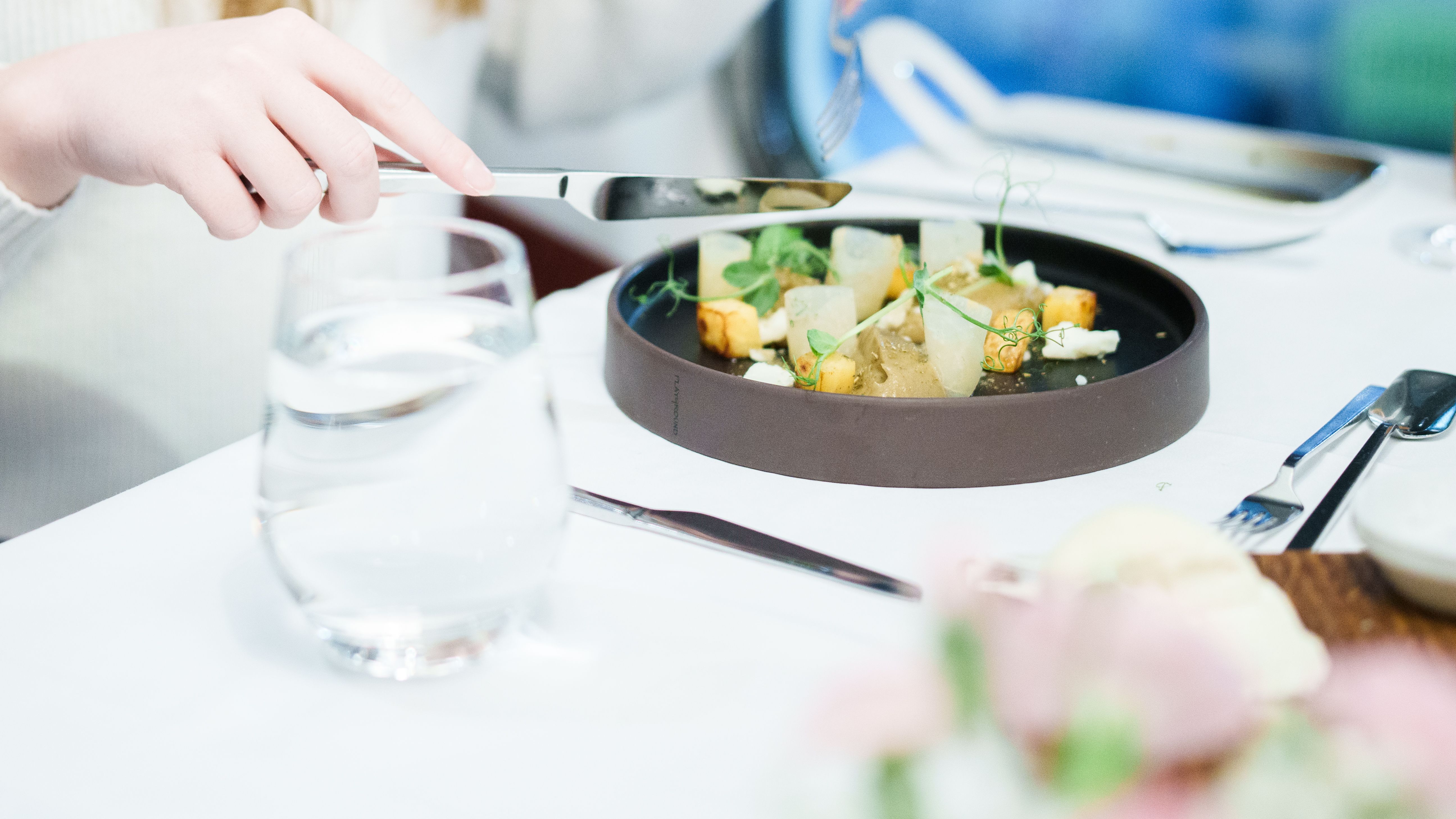 A well-presented starter with coulourful vegetables on a black plate