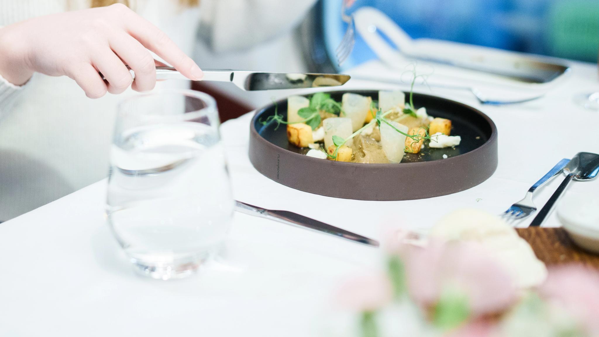 A well-presented starter with coulourful vegetables on a black plate