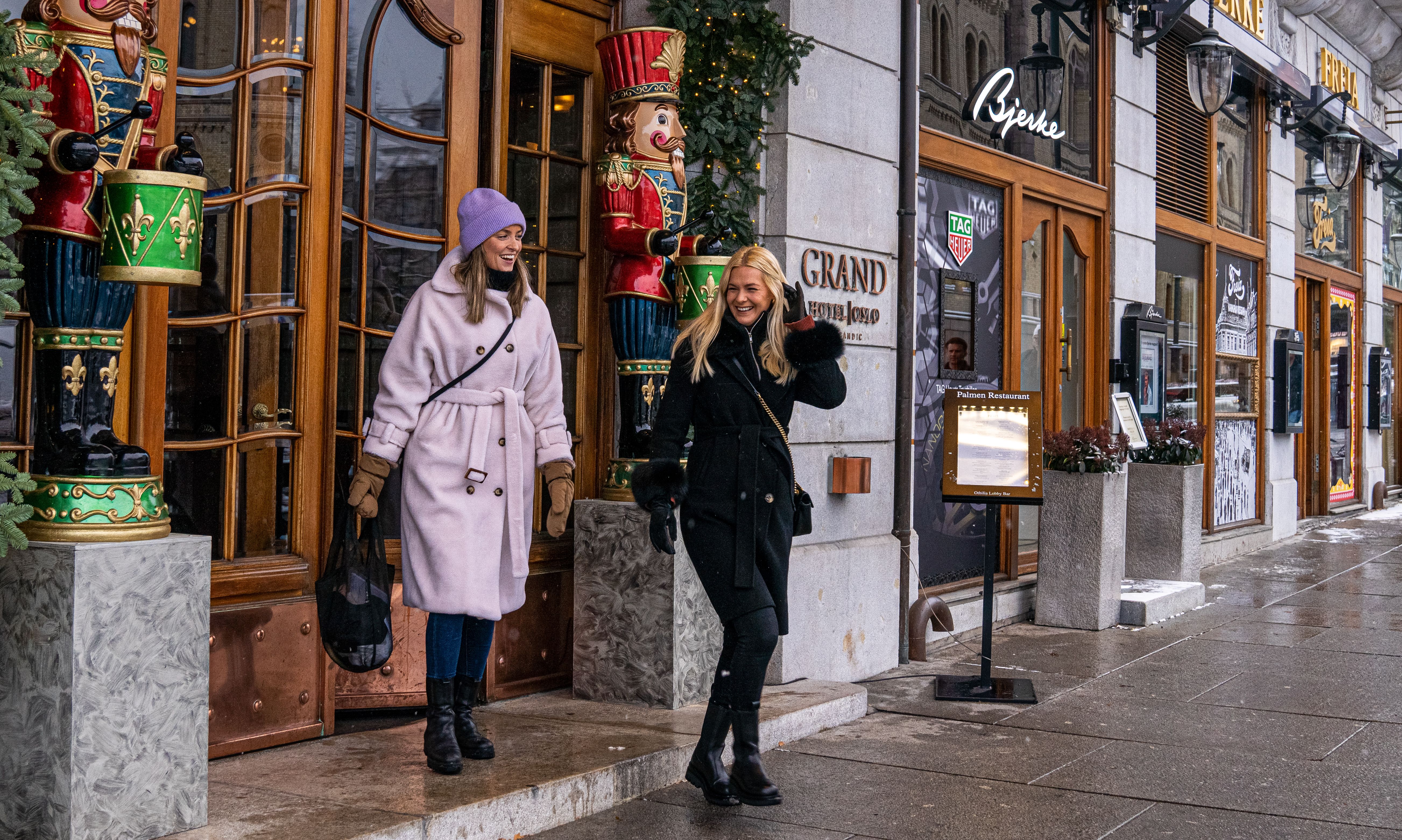 Two women on their way out of Grand hotel in Oslo, Eastern Norway
