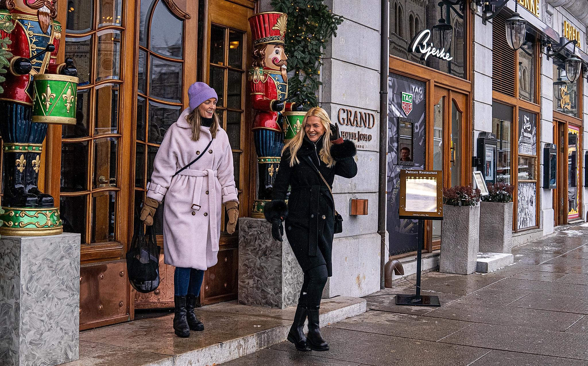 Two women on their way out of Grand hotel in Oslo, Eastern Norway