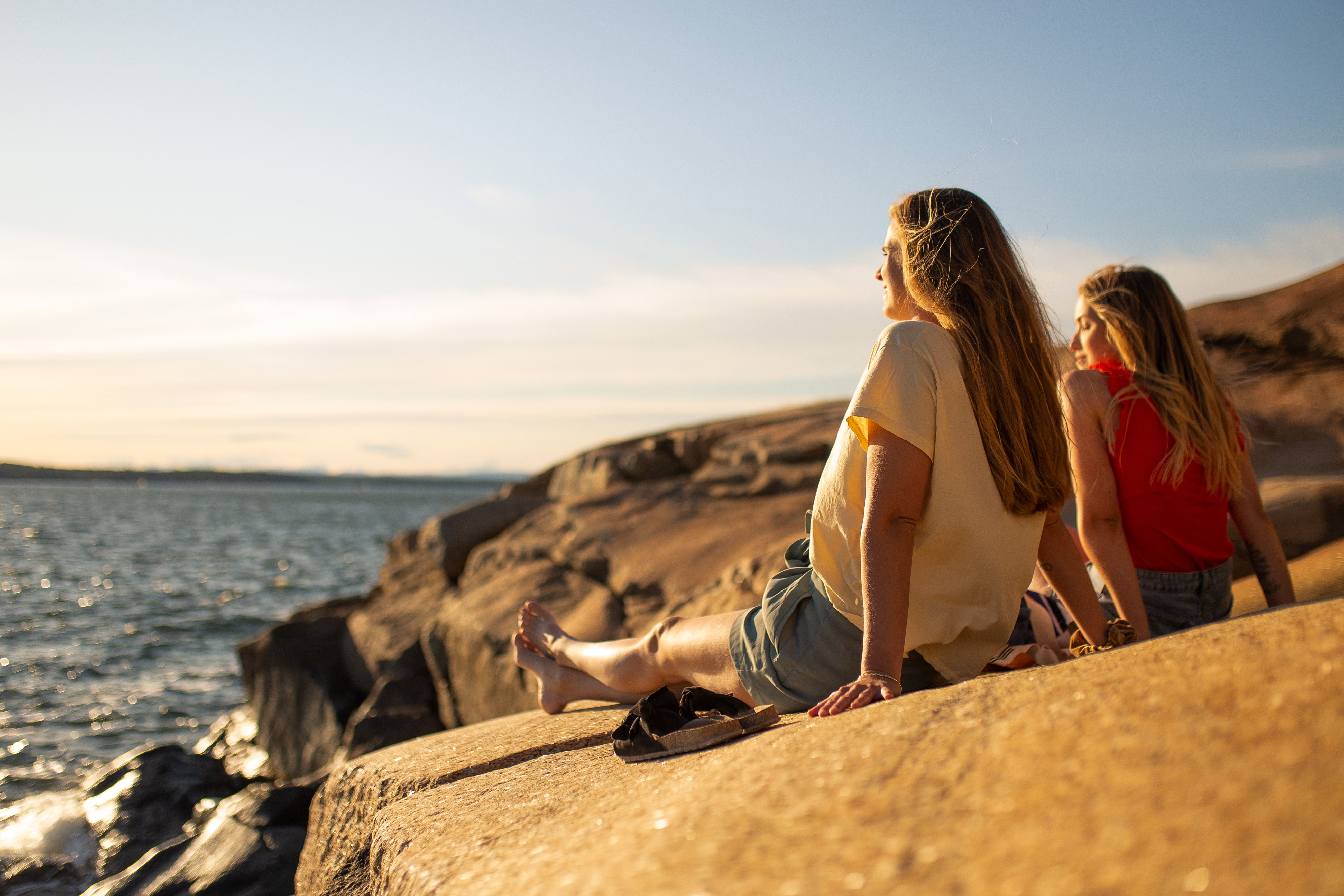 Two women are enjoying the sun at the skerries by the sea in Sandefjord in Eastern Norway