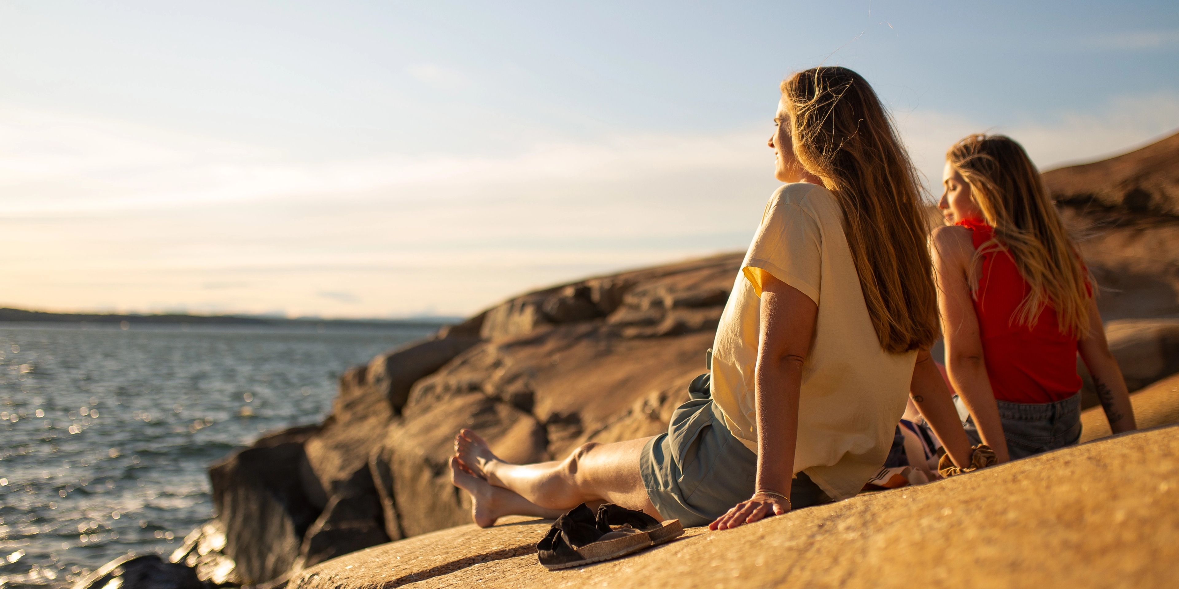 Two women are enjoying the sun at the skerries by the sea in Sandefjord in Eastern Norway