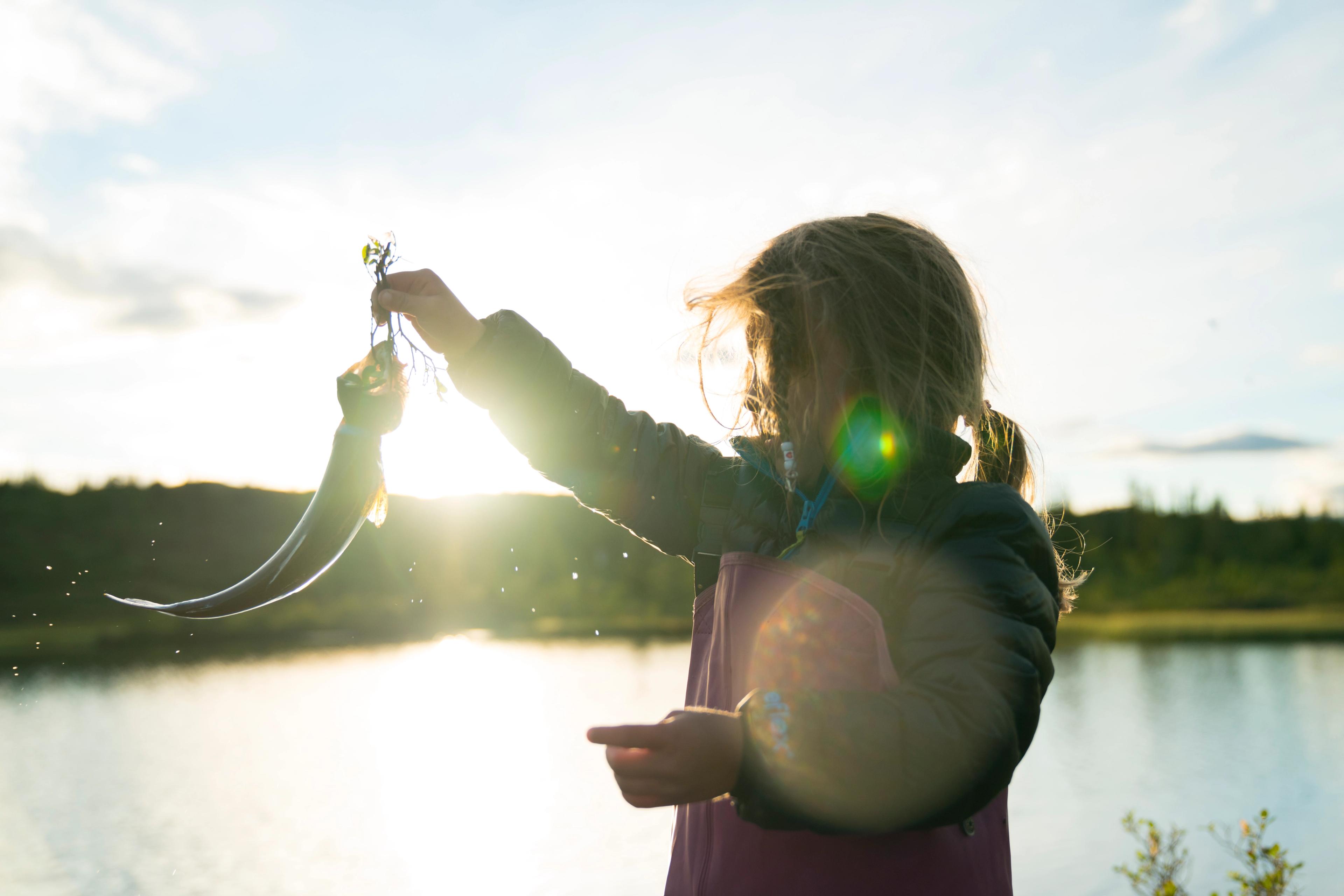 A girl is holding up a fish she caught while fishing in Blefjell in Eastern Norway.