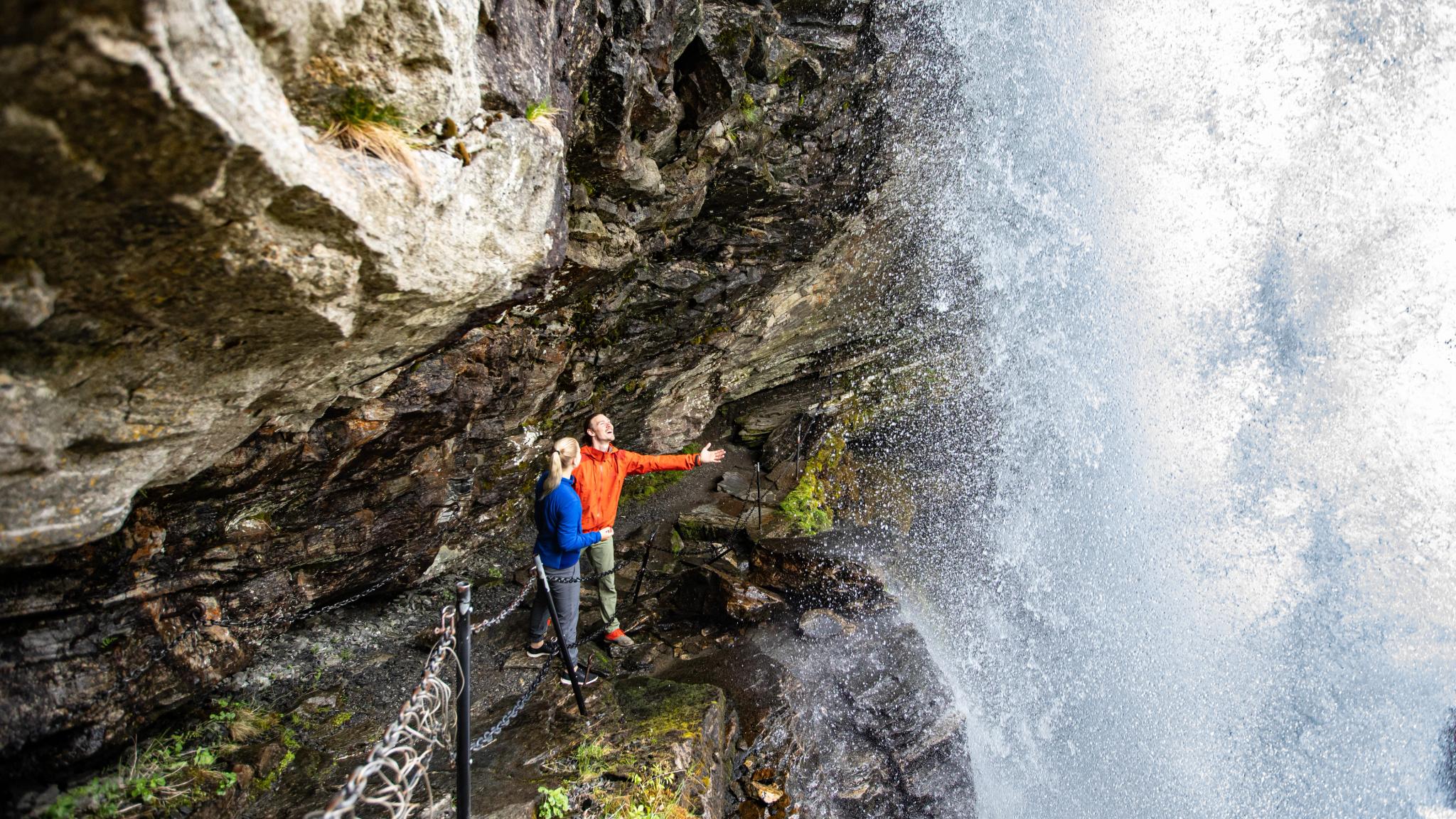 To personer under fossen Fosseråsa i Geiranger, Vestlandet