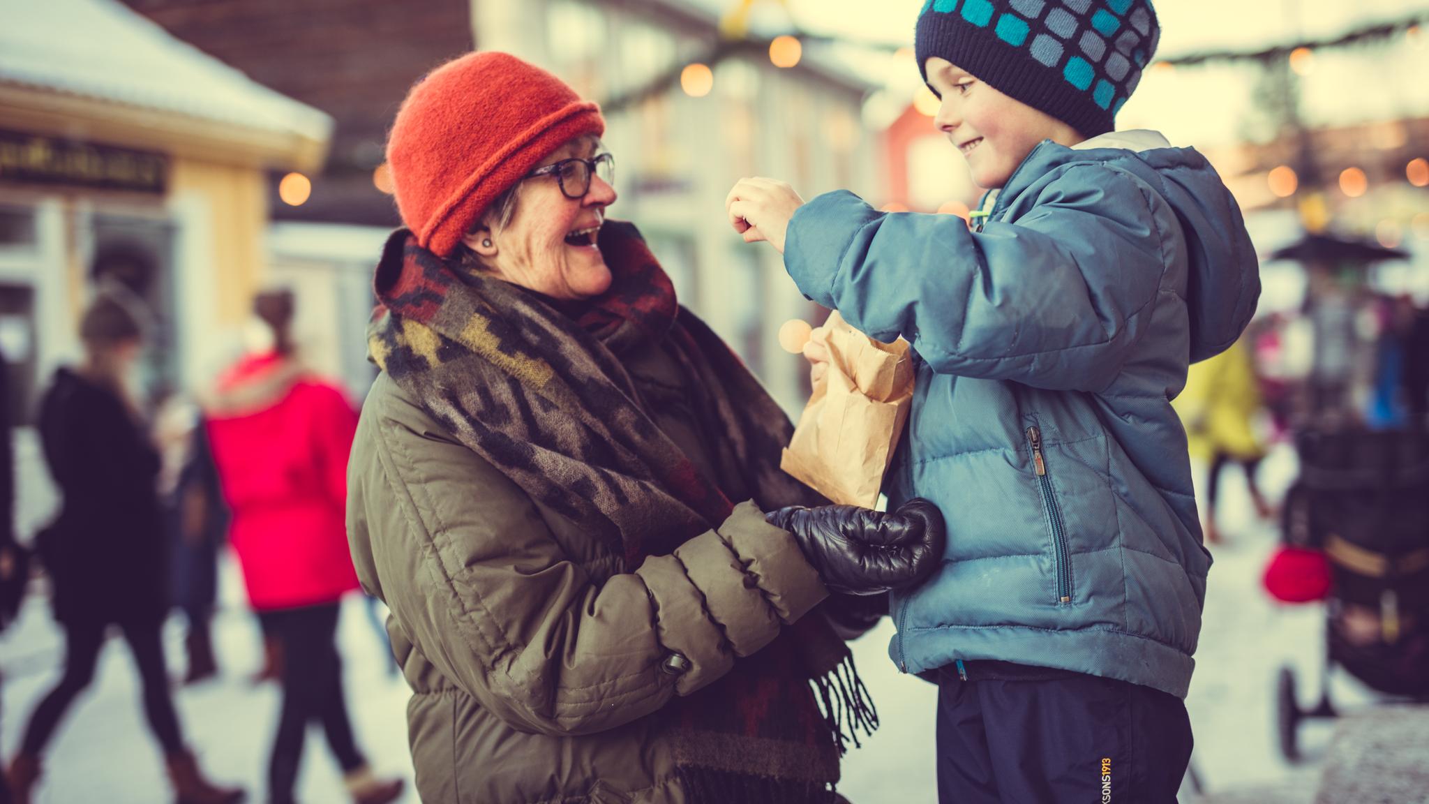 Elderly woman and little boy at Christmas market at Maihaugen Museum in Lillehammer