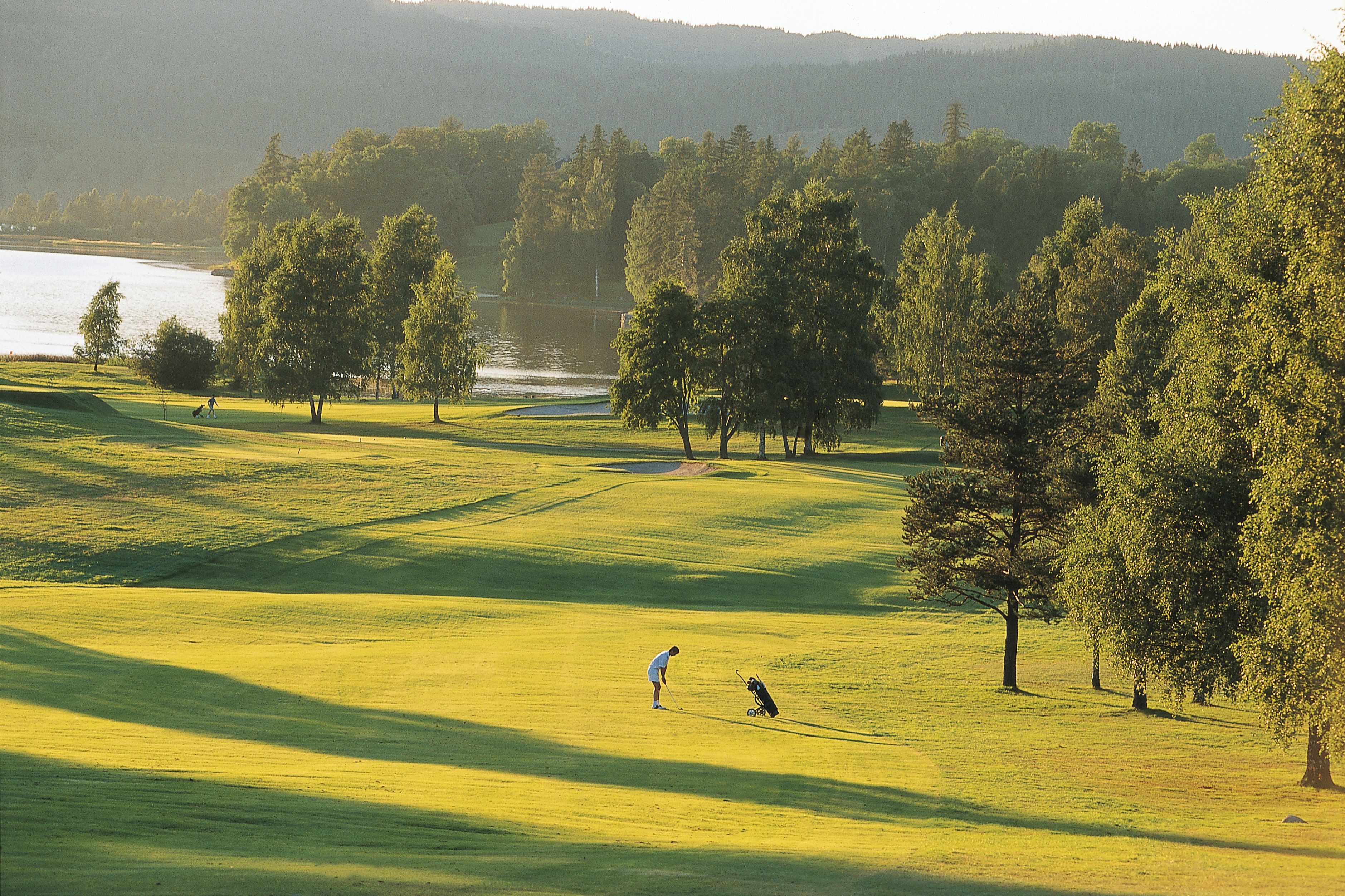 A person playing golf in the distance at Bogstad golf course in Oslo