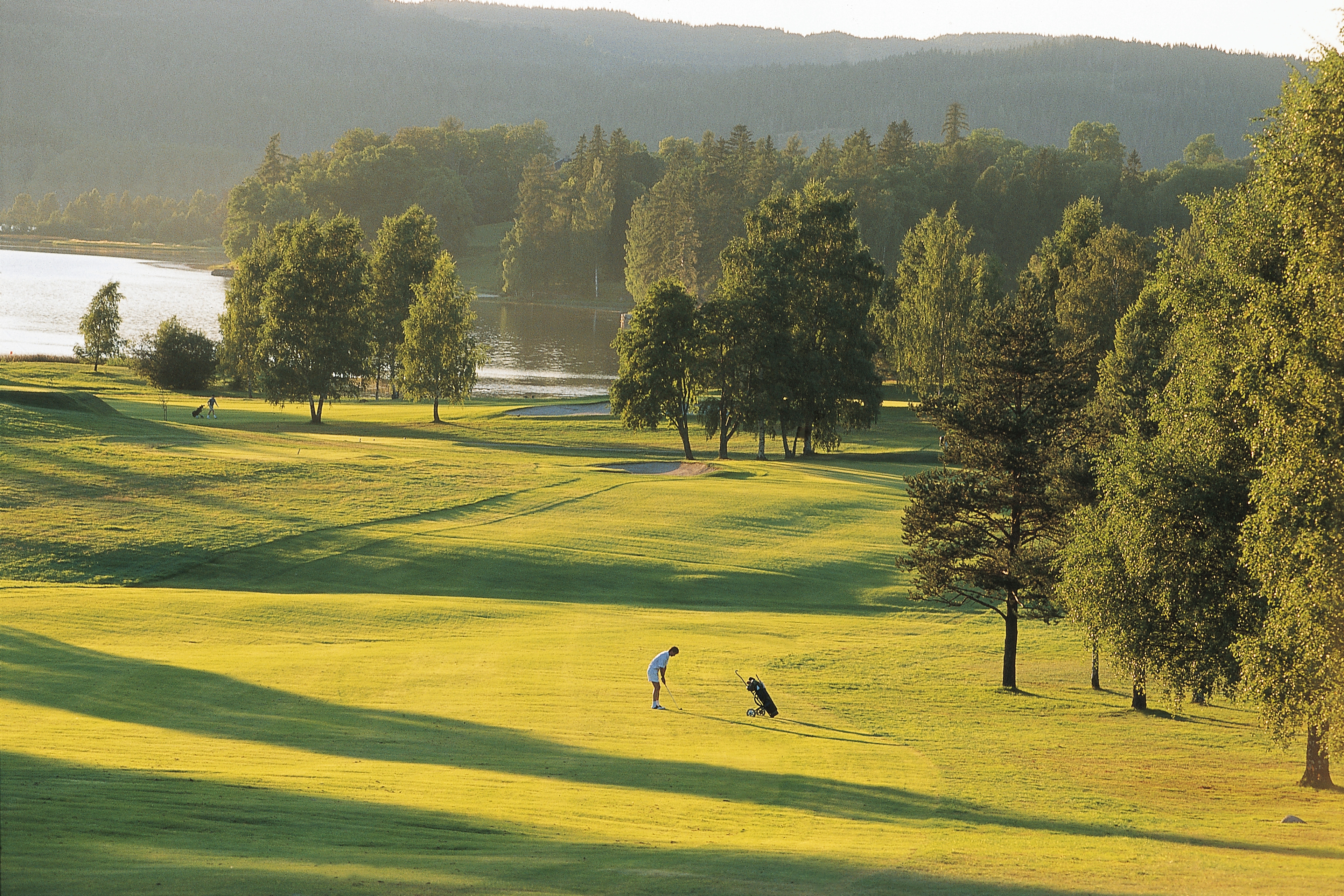 A person playing golf in the distance at Bogstad golf course in Oslo