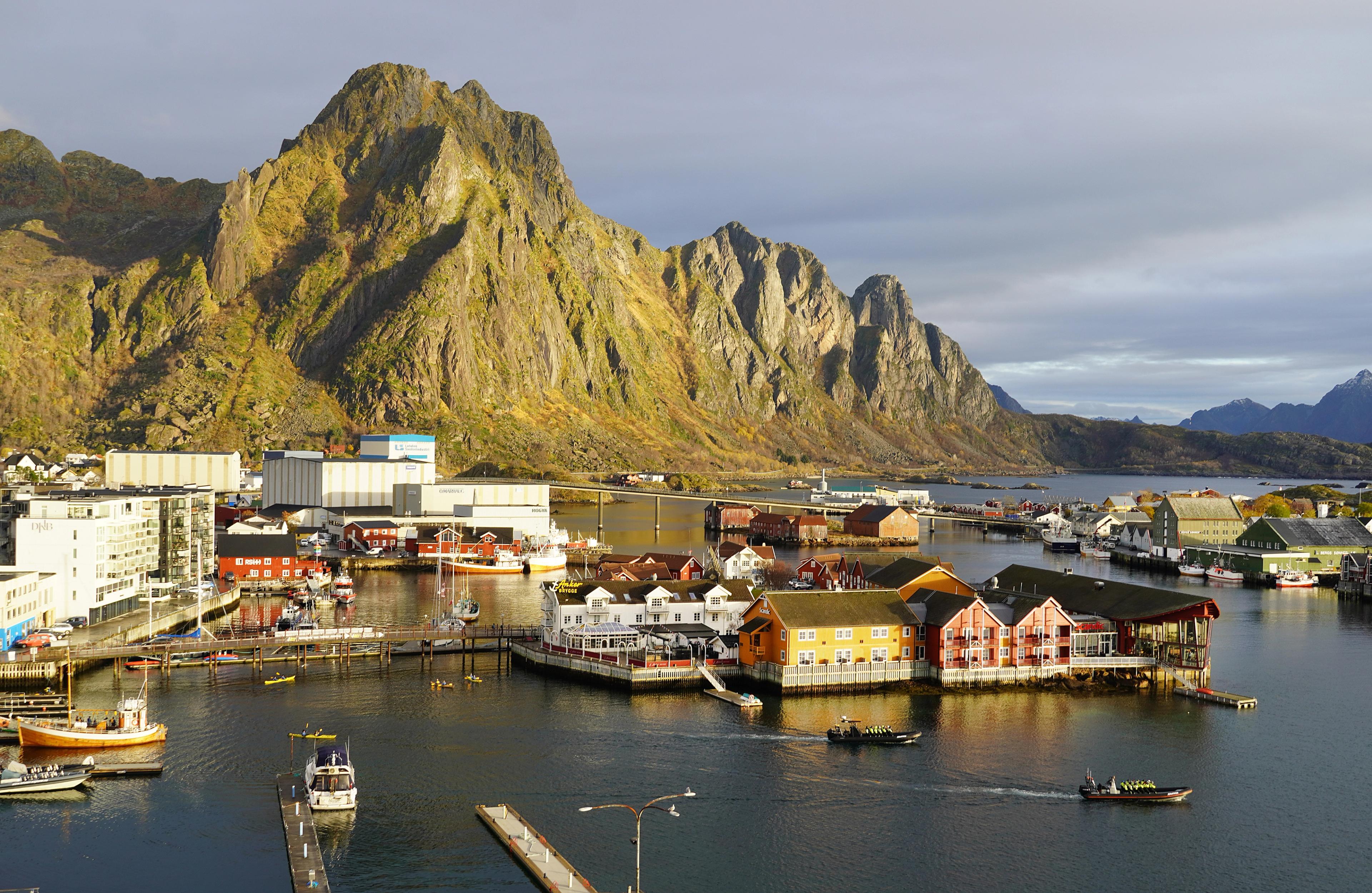 The tourist town and fishing village of Svolvær in Lofoten below tall mountains.