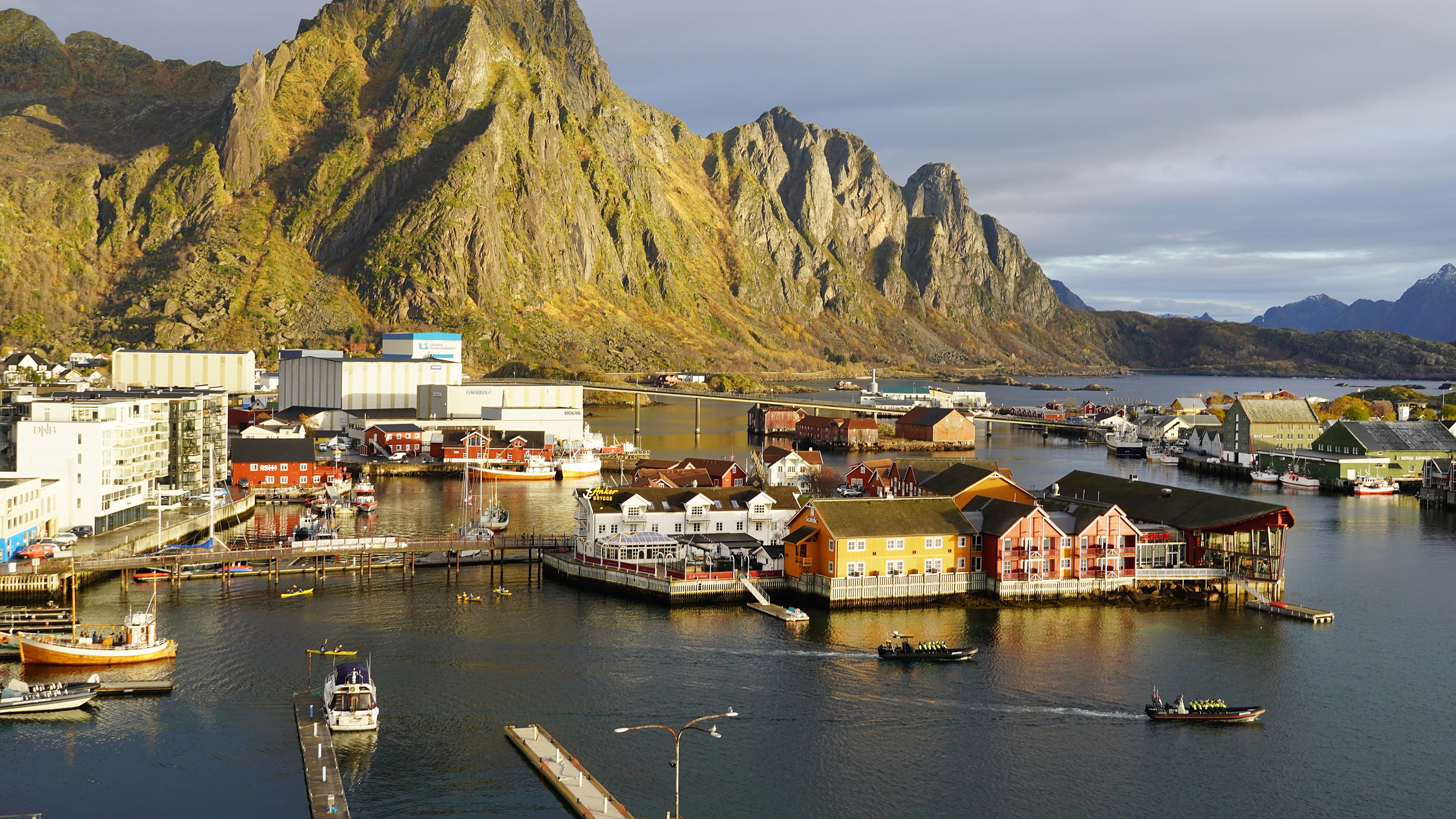 The tourist town and fishing village of Svolvær in Lofoten below tall mountains.