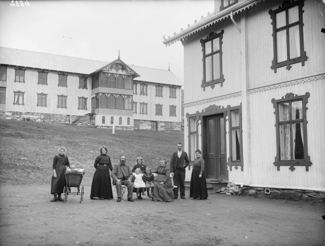 Old photo of the Hjerkinn family outside of Hjerkinn Fjeldstue, mountain lodge.