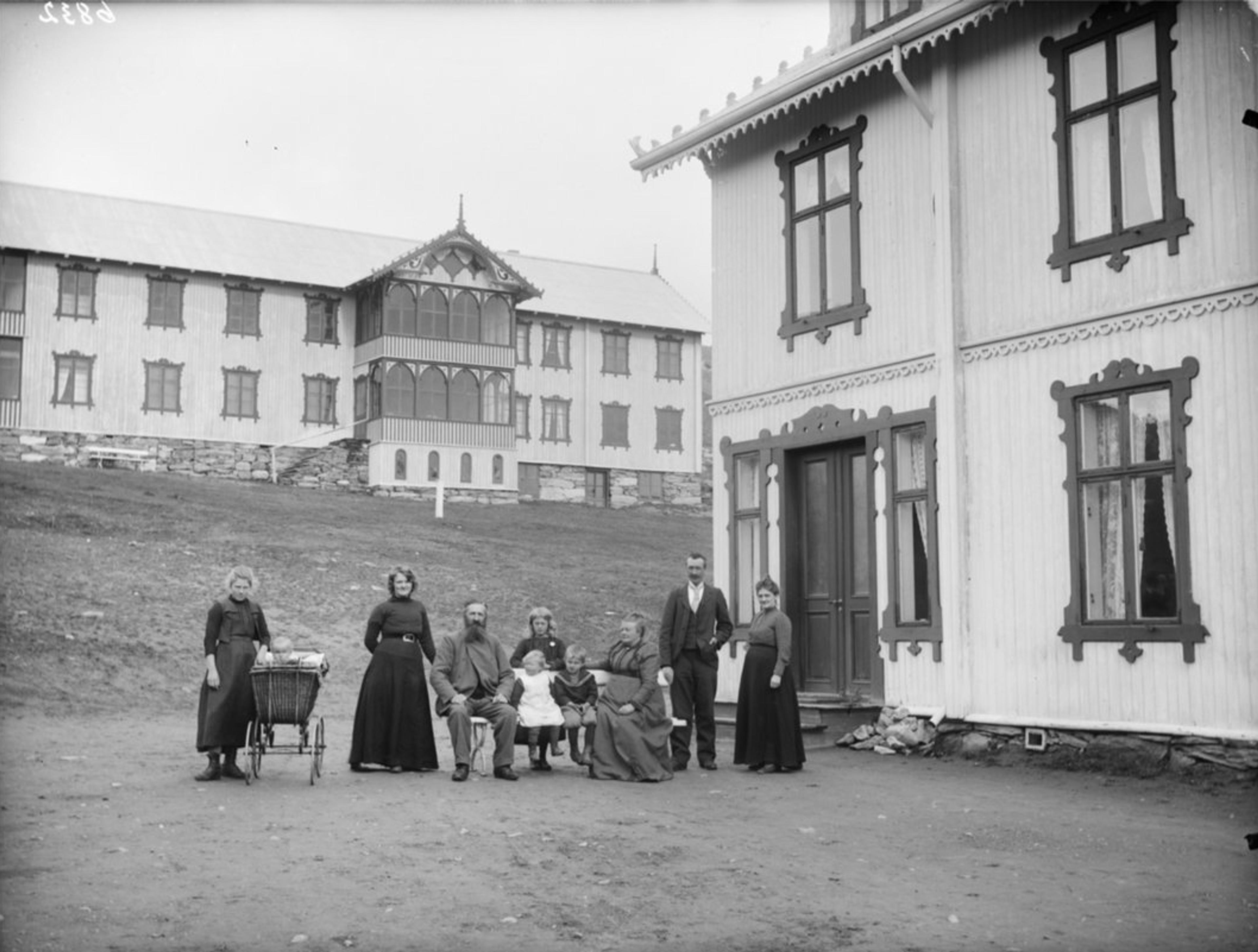 Old photo of the Hjerkinn family outside of Hjerkinn Fjeldstue, mountain lodge.