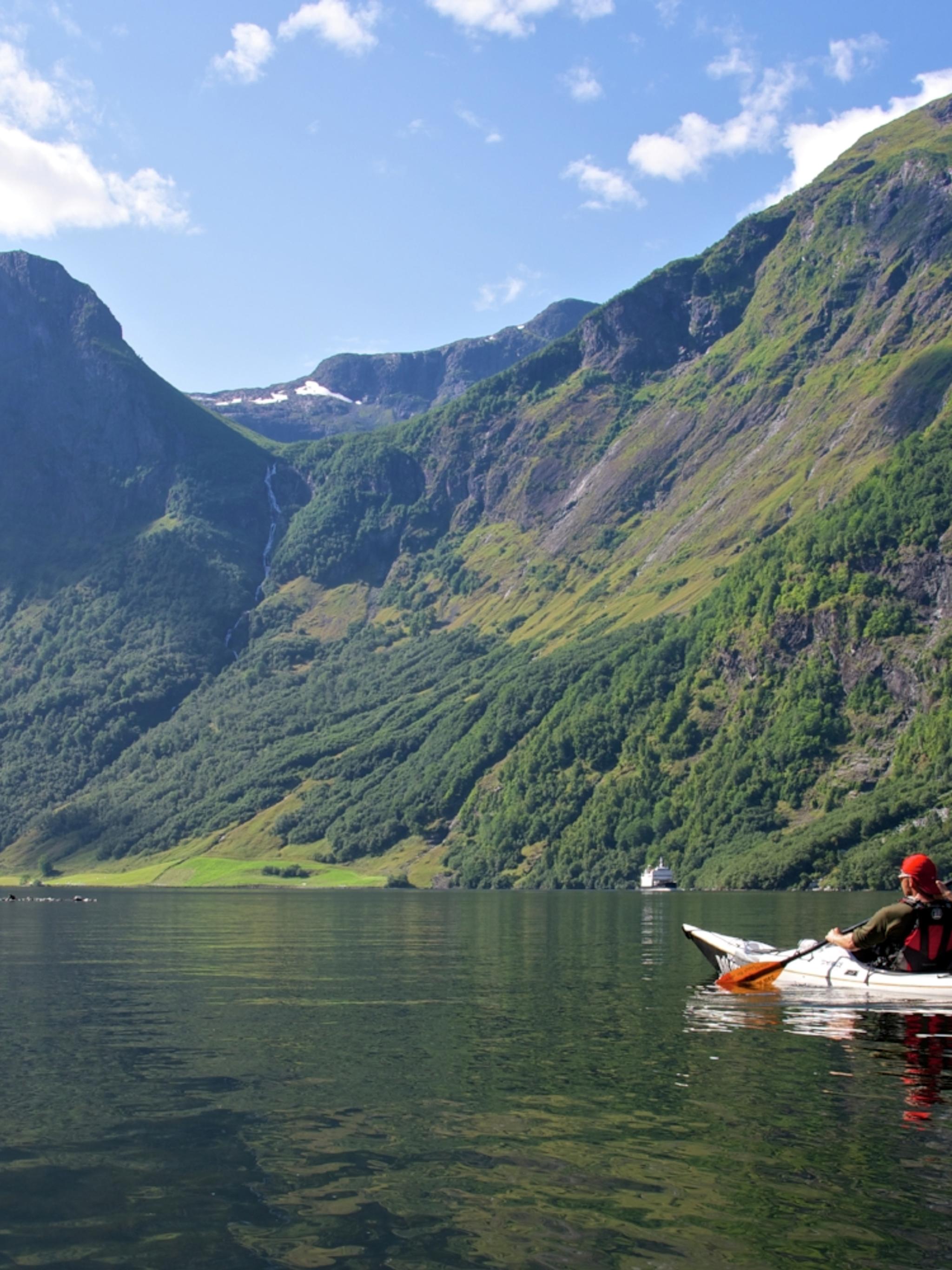 A person paddling in the Nærøyfjord in Fjord Norway