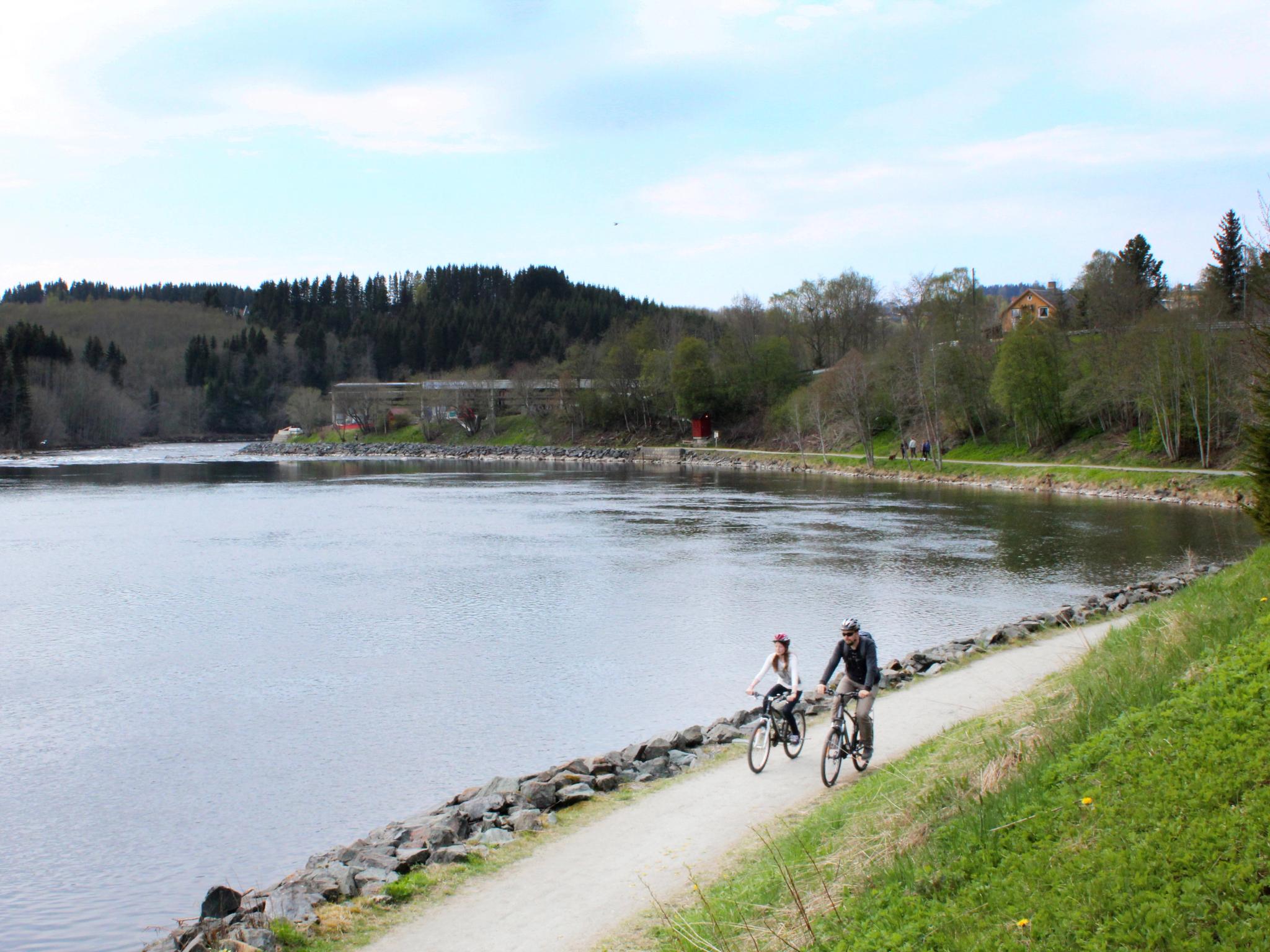 Father and daughter cycling along the Nidelva river in Trondheim, Trøndelag