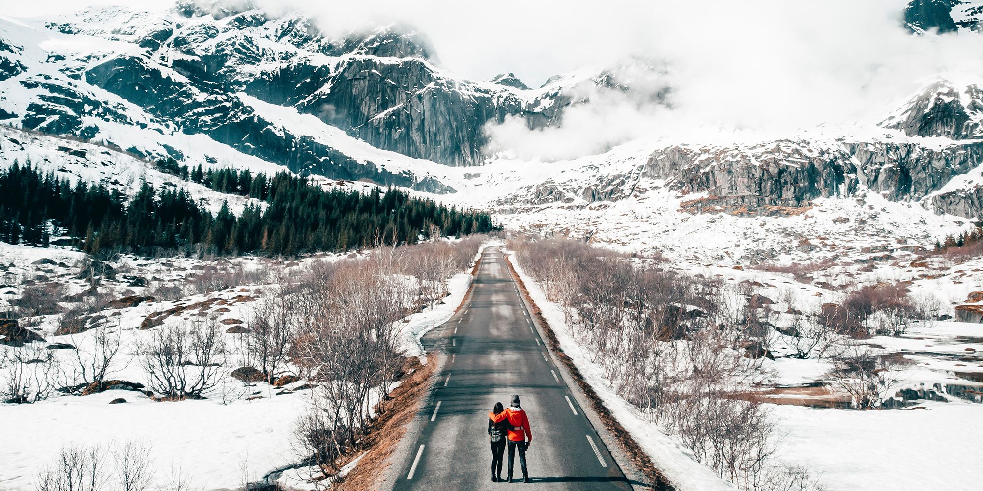 A couple on a road in a winter-clad Lofoten, Northern Norway