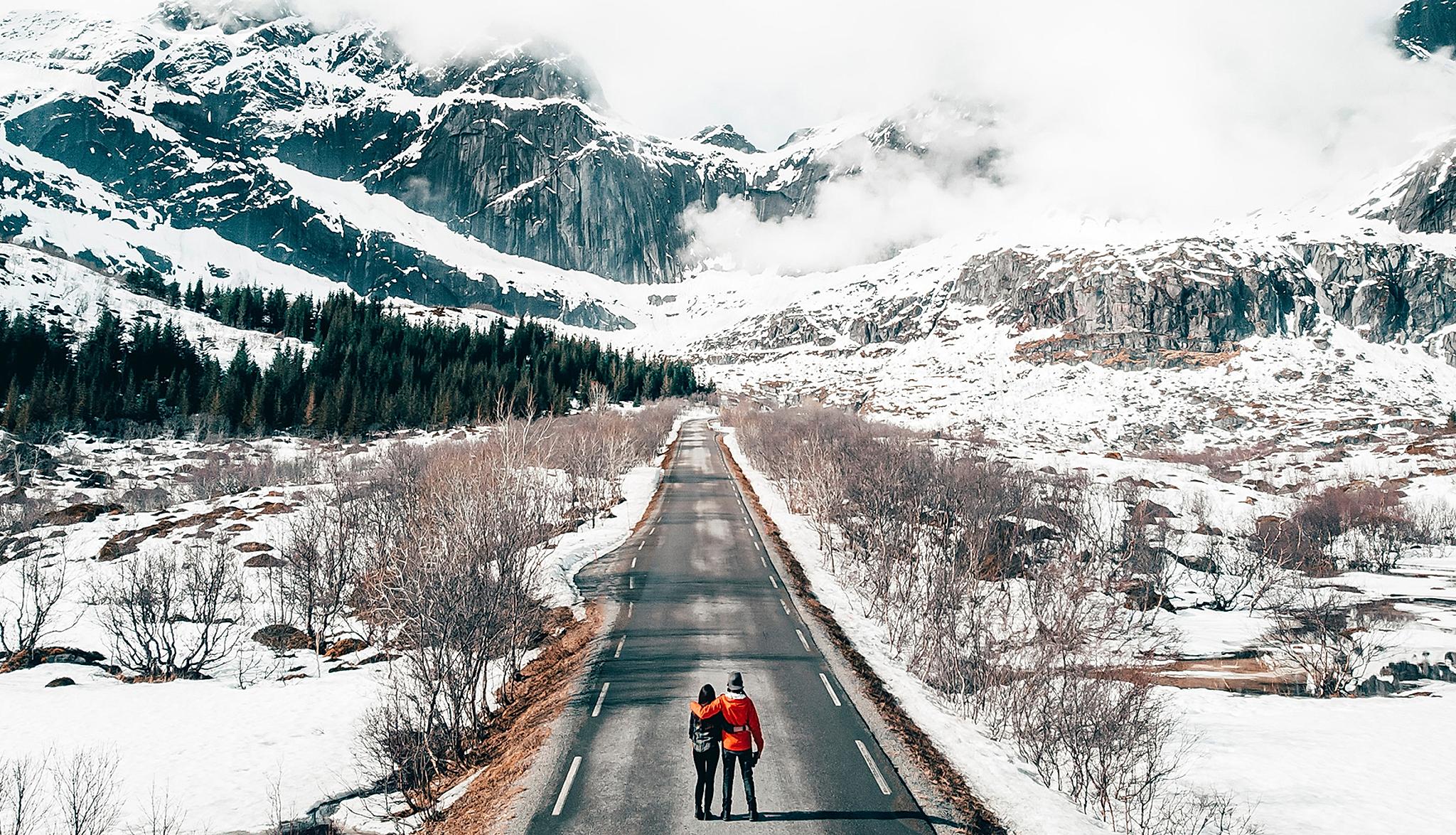 A couple on a road in a winter-clad Lofoten, Northern Norway