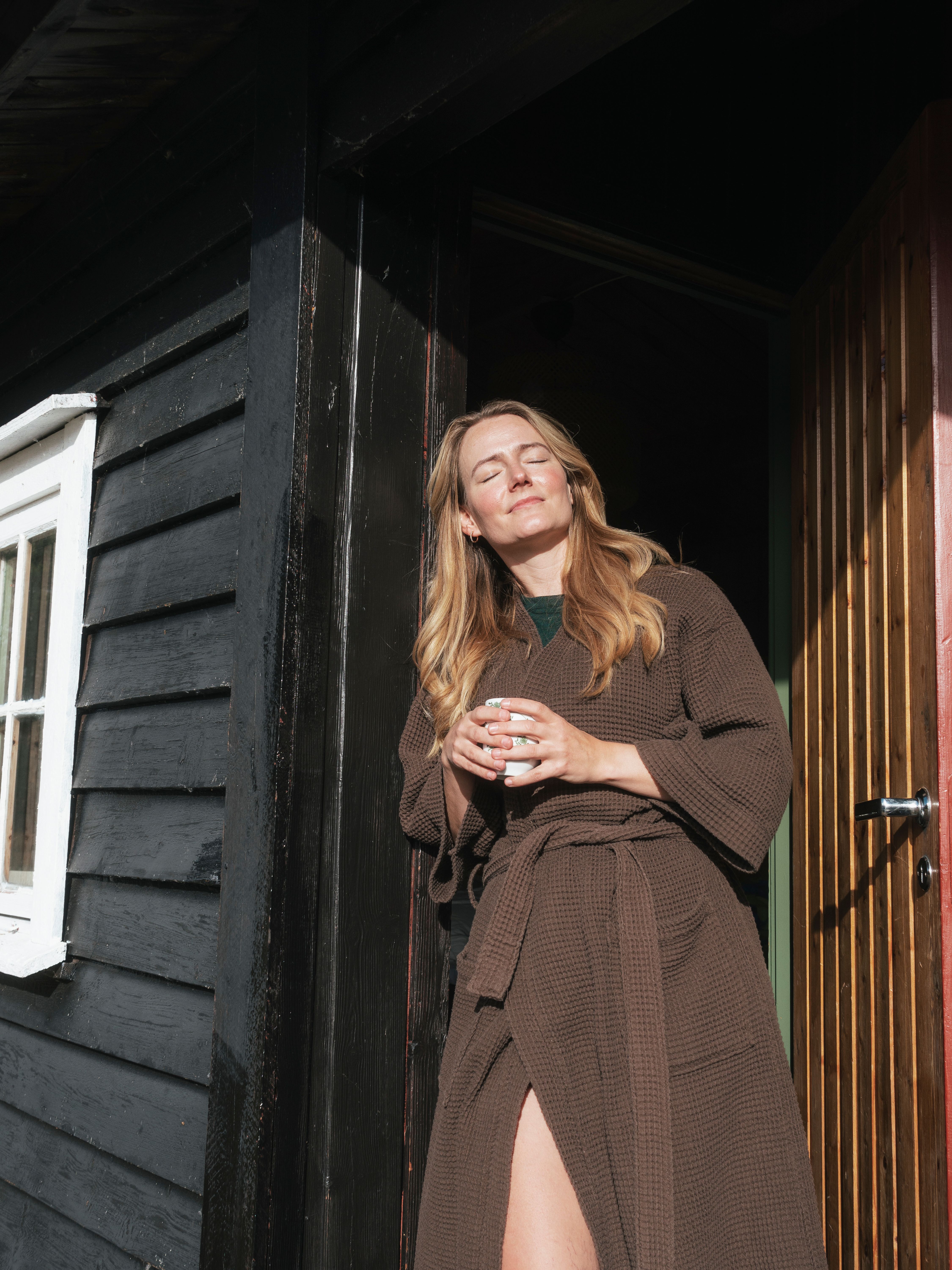A woman enjoying the sun on her face at a mountain cabin in Southern Norway