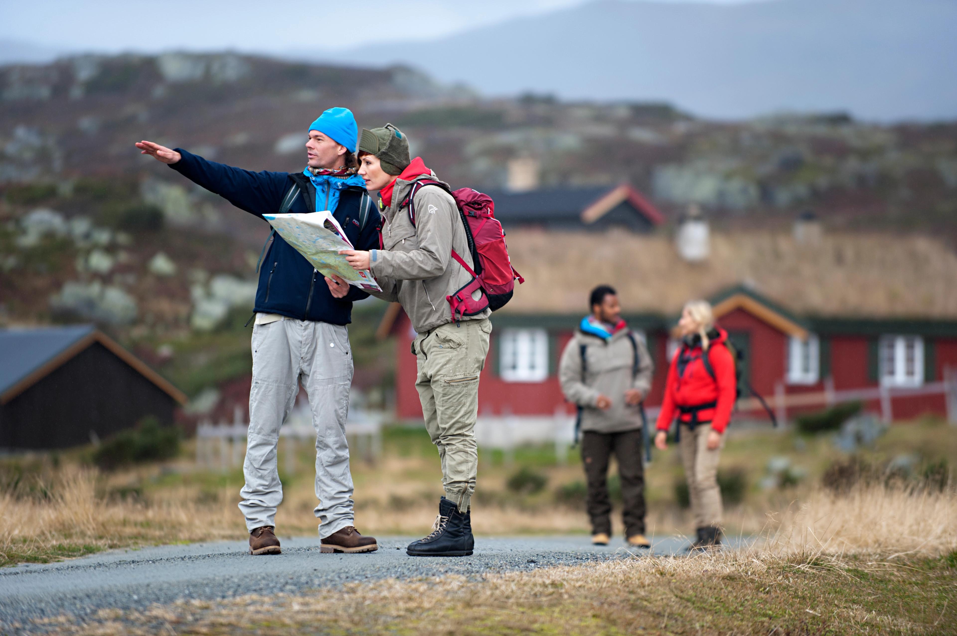 Four people hiking and looking at the map for where to hike in Beitostølen in Eastern Norway