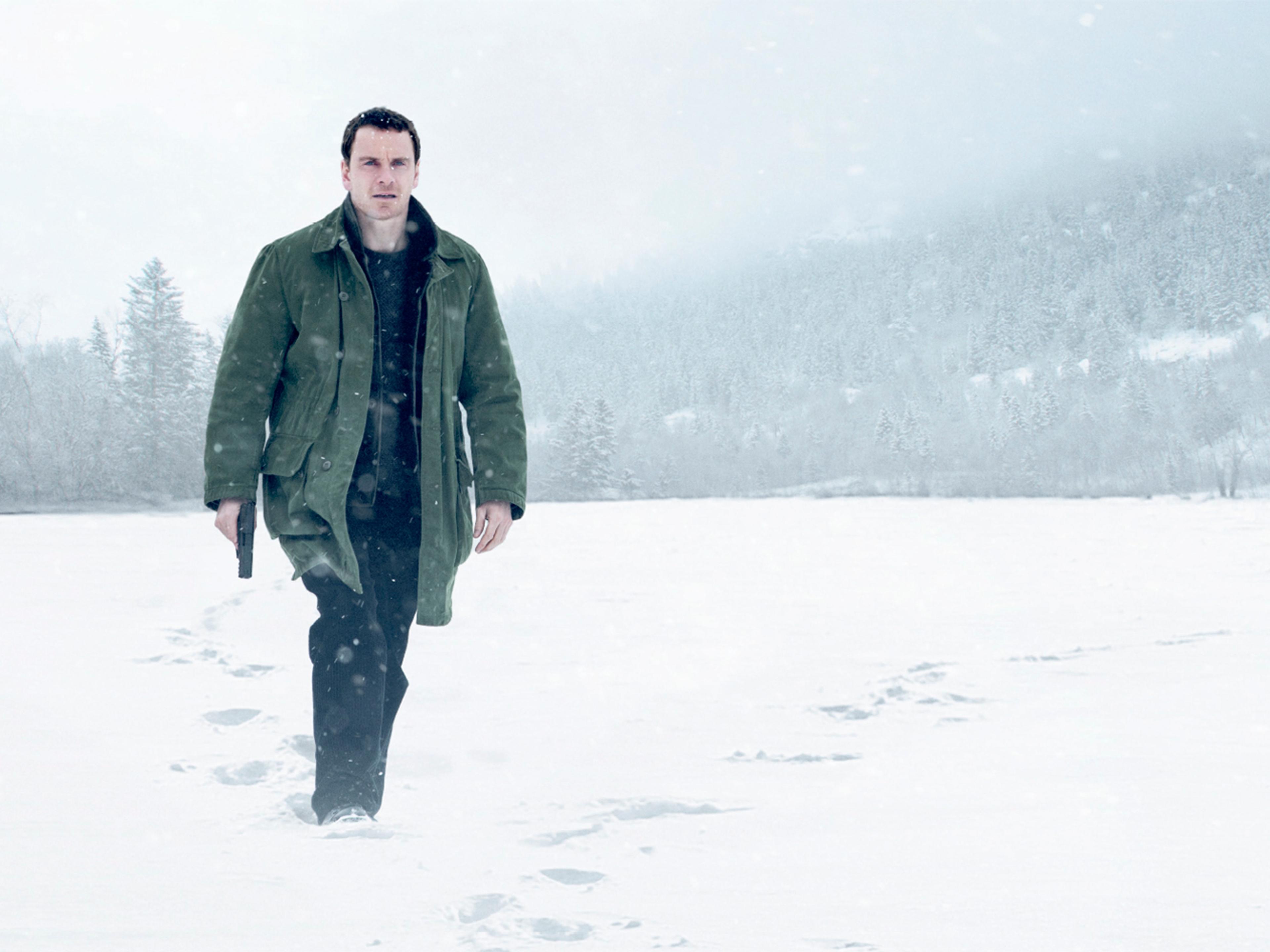 A man with a gun walking in the snow. From the movie poster for Jo Nesbø’s The Snowman.