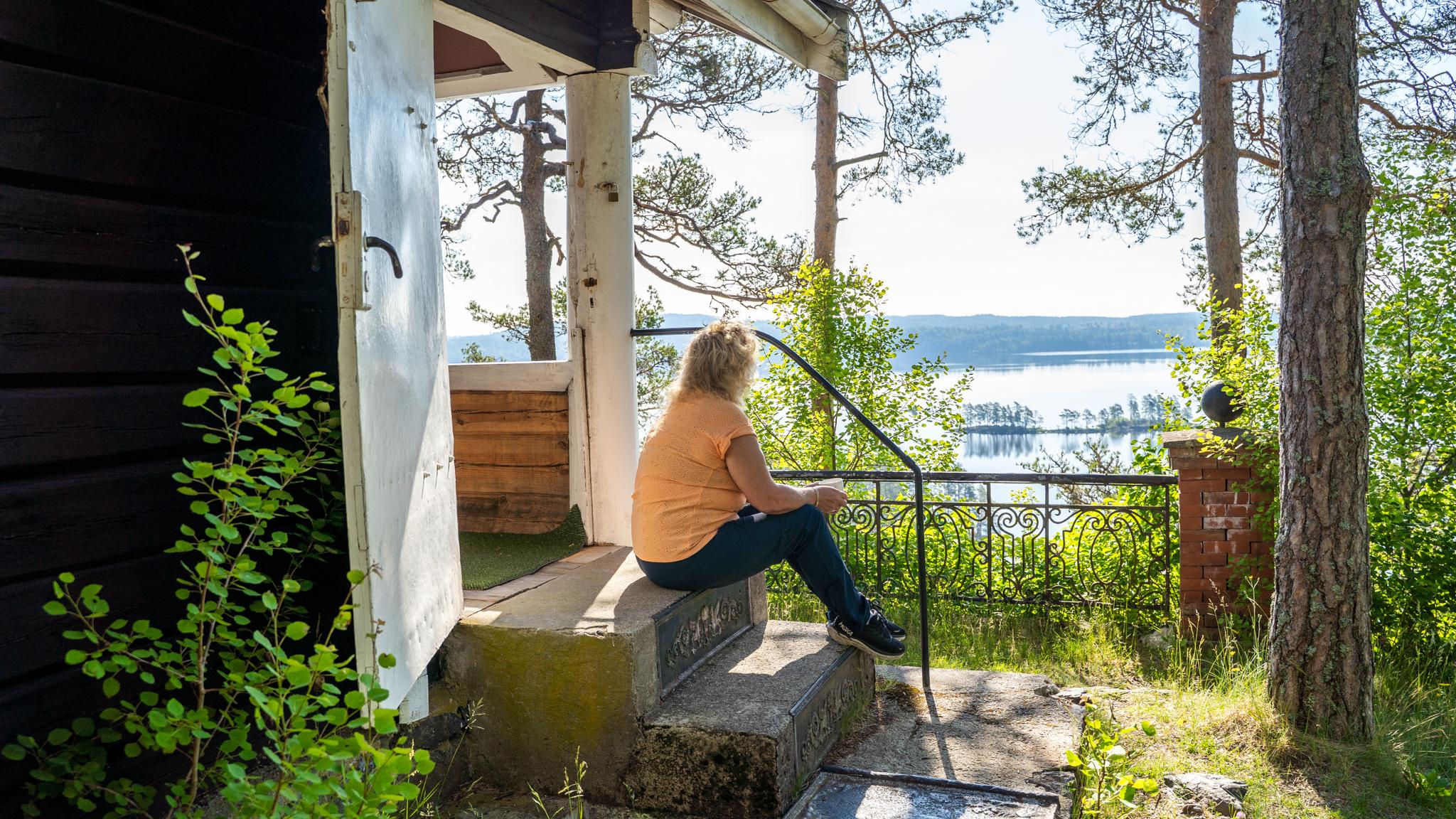 Woman sitting outside of the Flagghytta cabin by the Halden Canal in Eastern Norway.