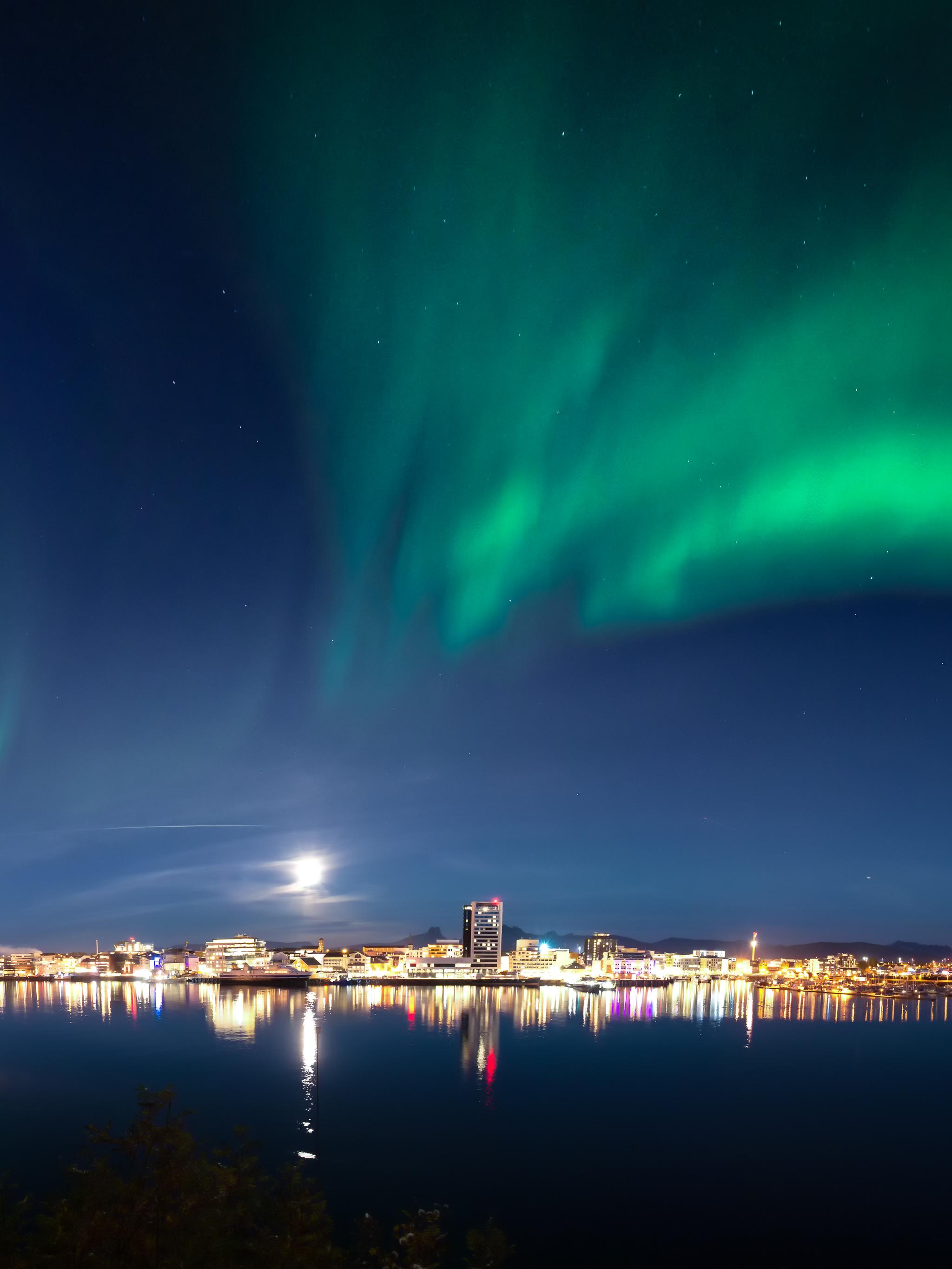 The northern lights dancing across the sky above the city of Bodø, Northern Norway