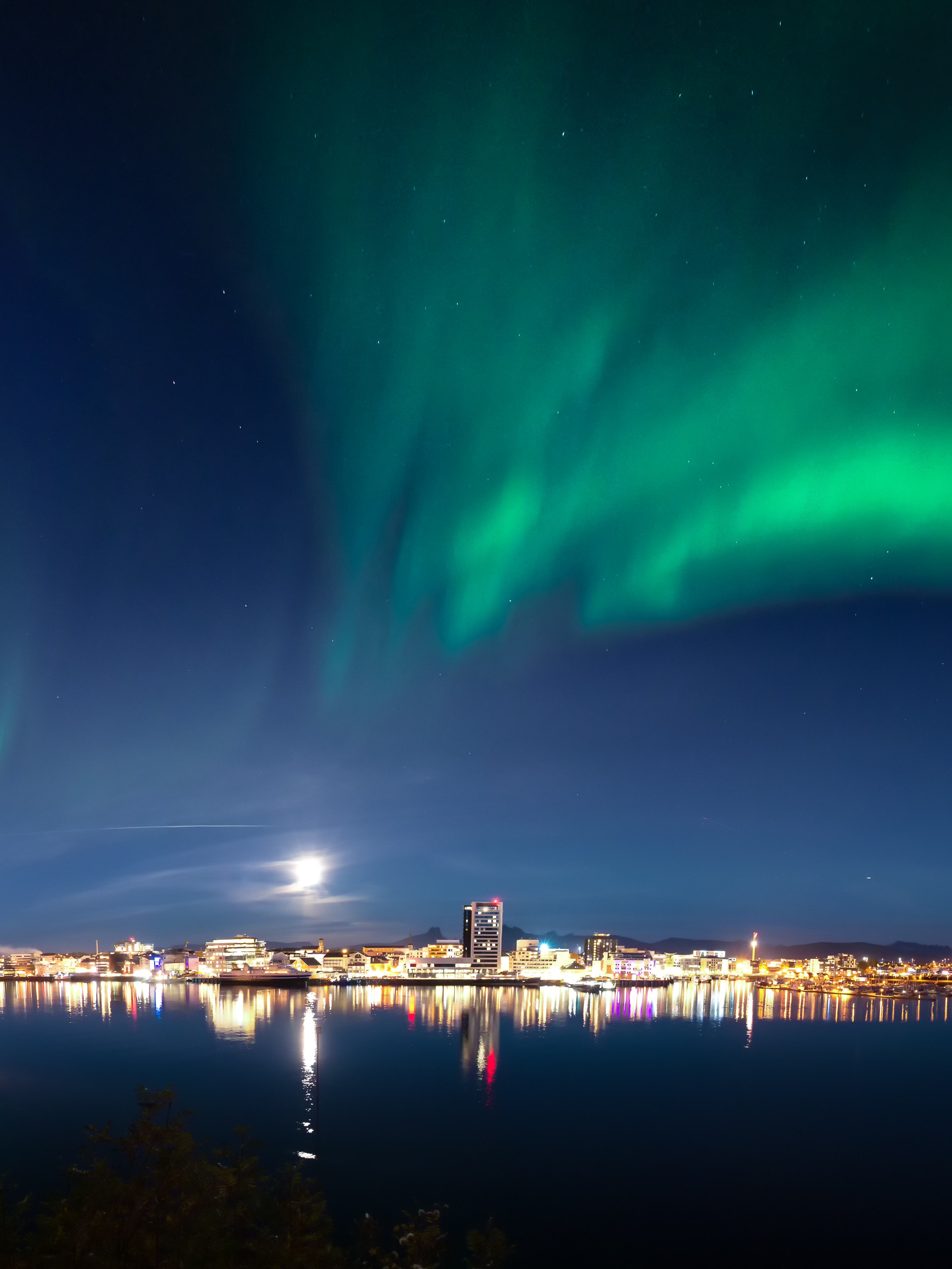 The northern lights dancing across the sky above the city of Bodø, Northern Norway