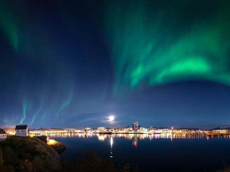 The northern lights dancing across the sky above the city of Bodø, Northern Norway