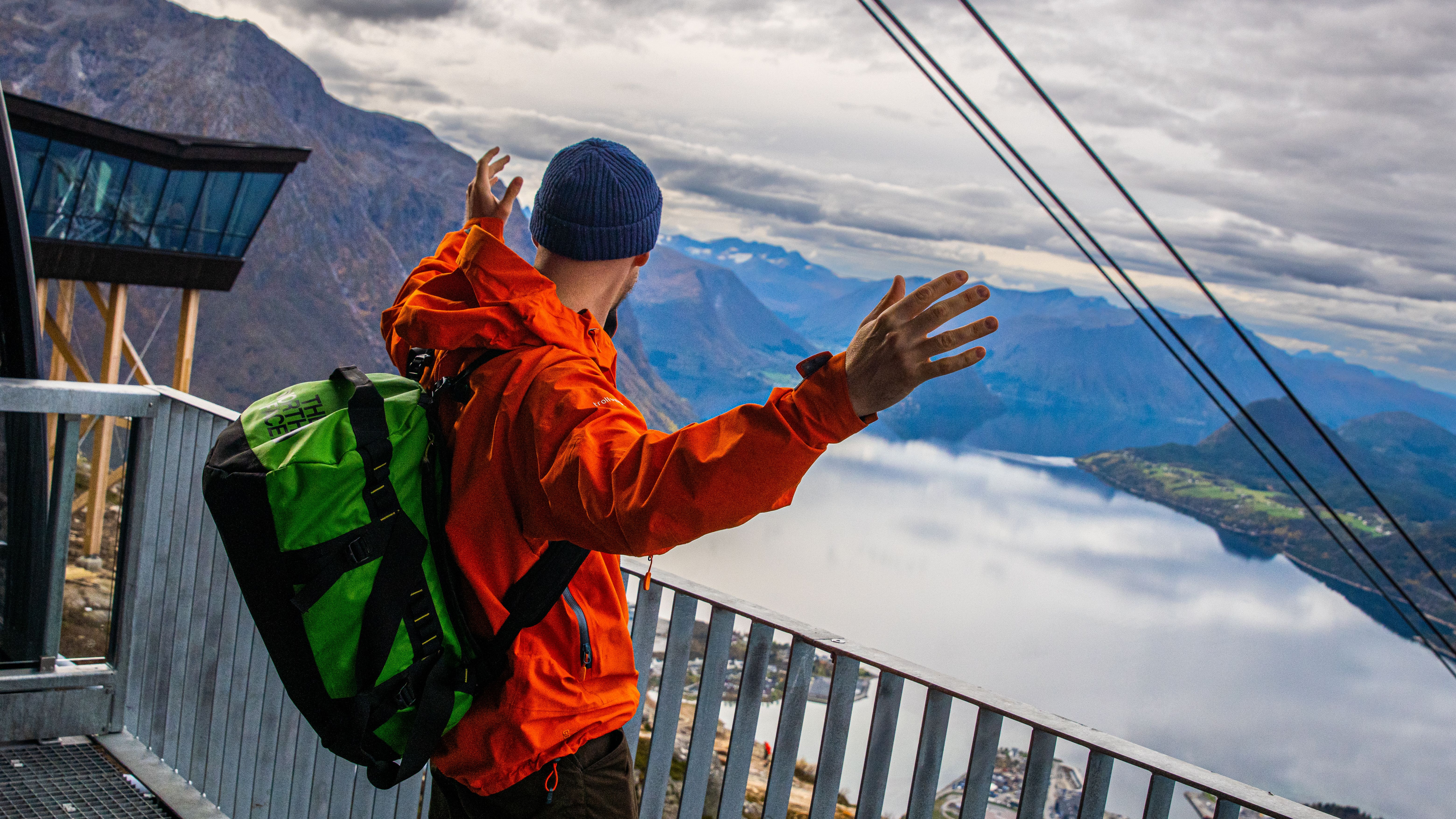 A man is standing on top of the Romsdal Gondola