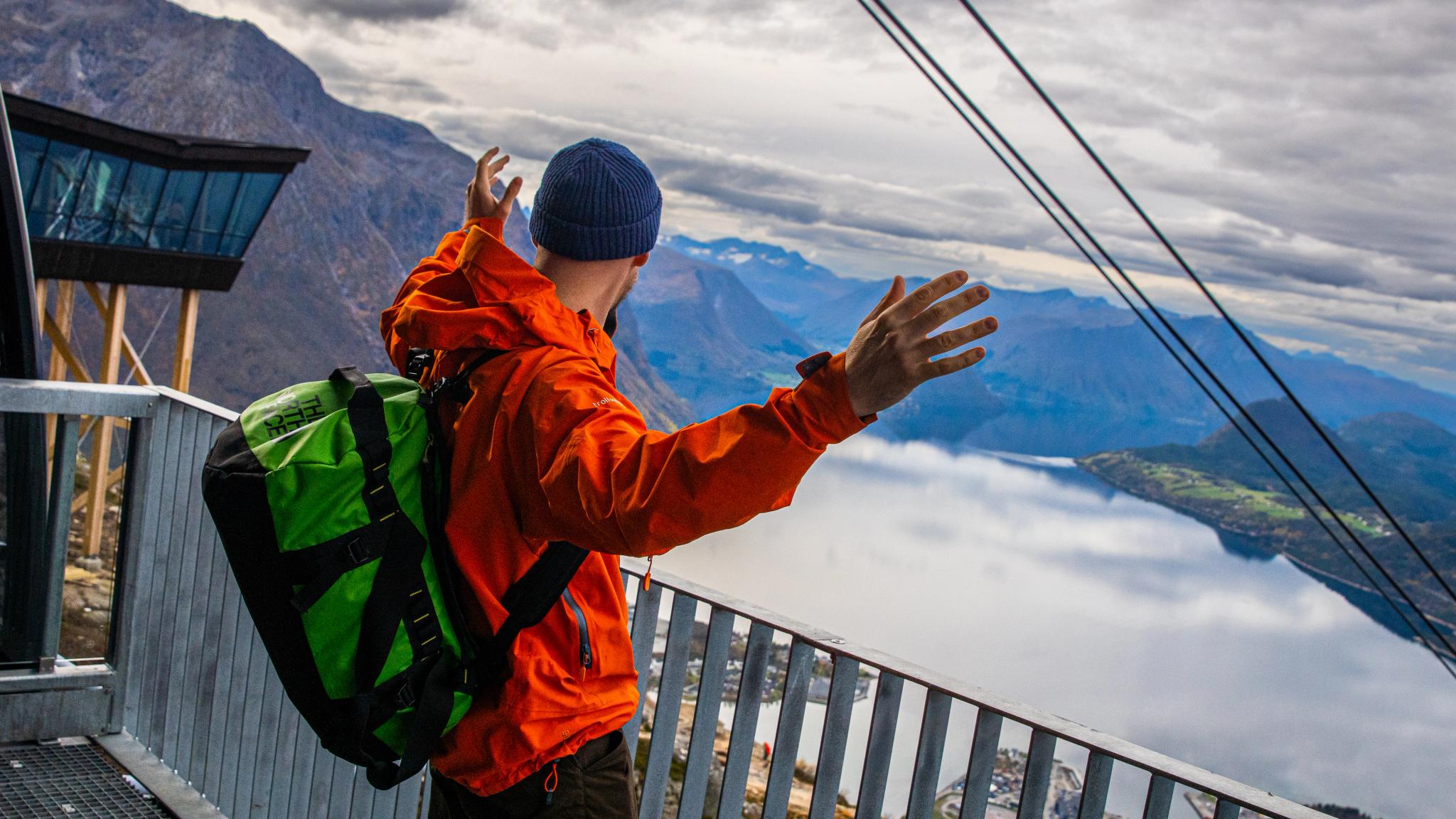 A man is standing on top of the Romsdal Gondola
