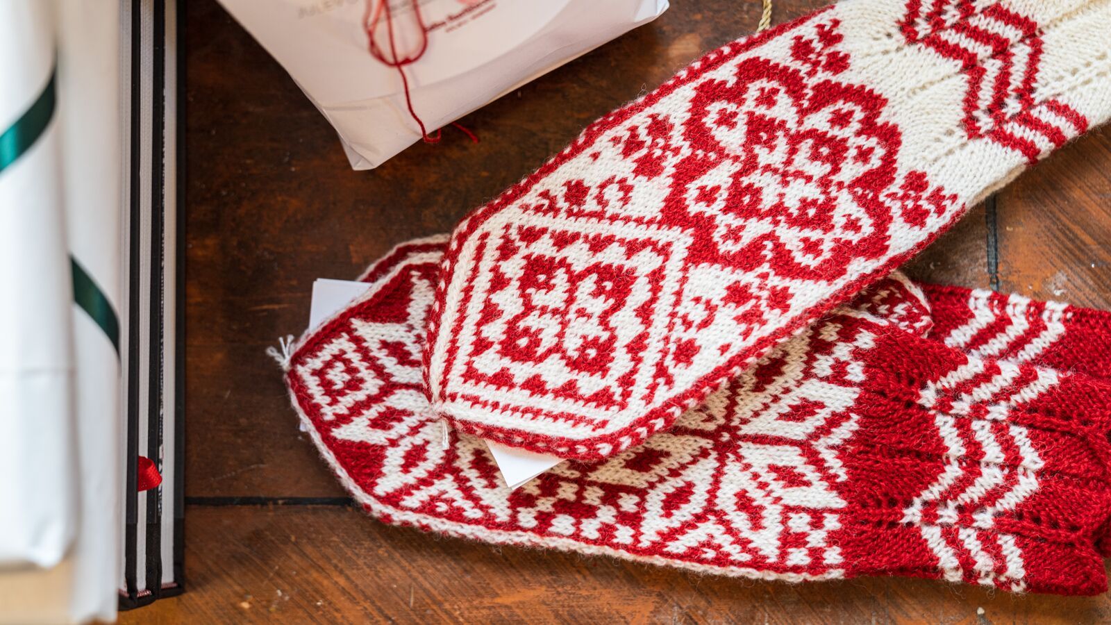 Red and white Selbu mittens on a table, Trøndelag, Norway.