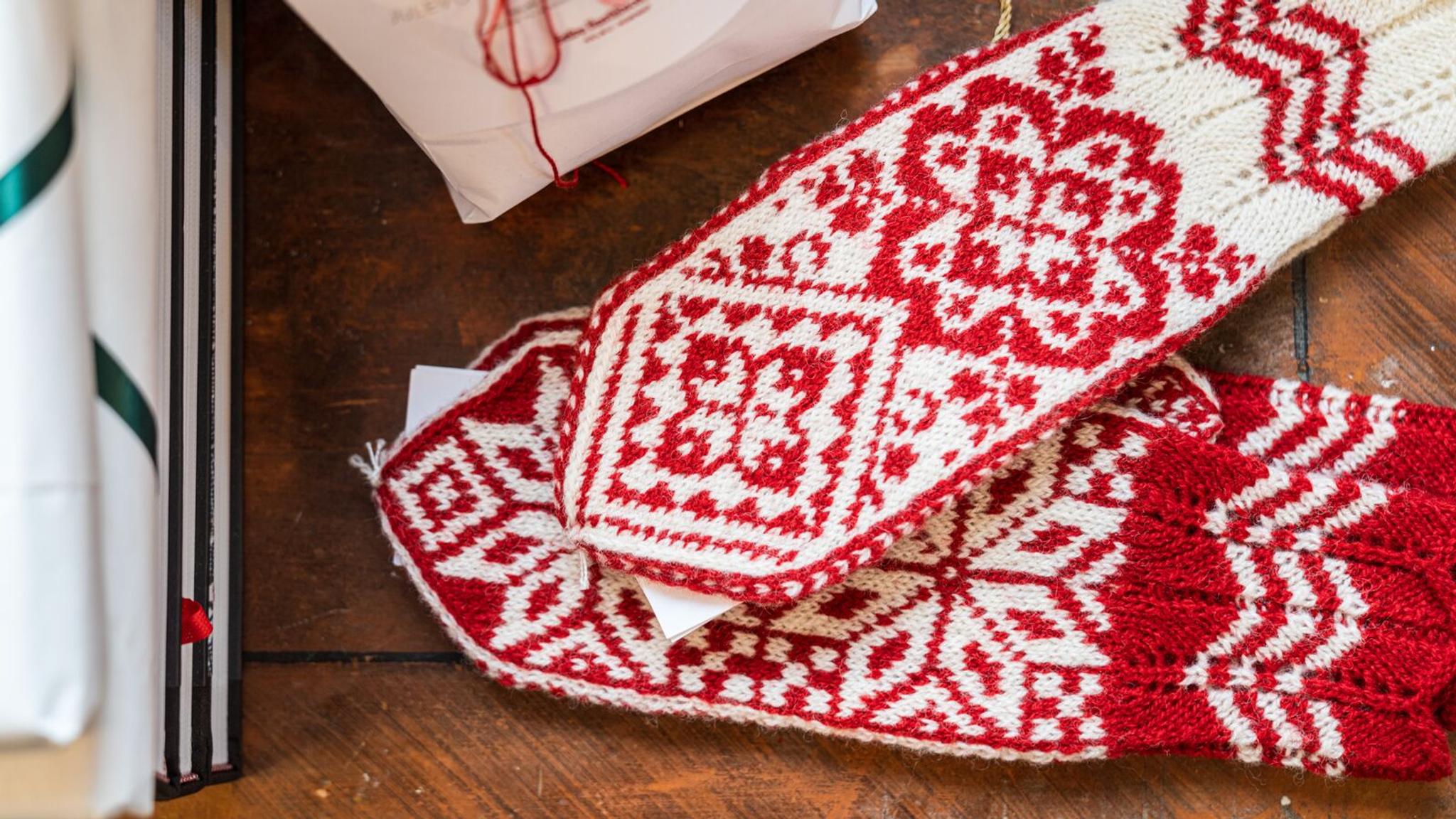 Red and white Selbu mittens on a table, Trøndelag, Norway.