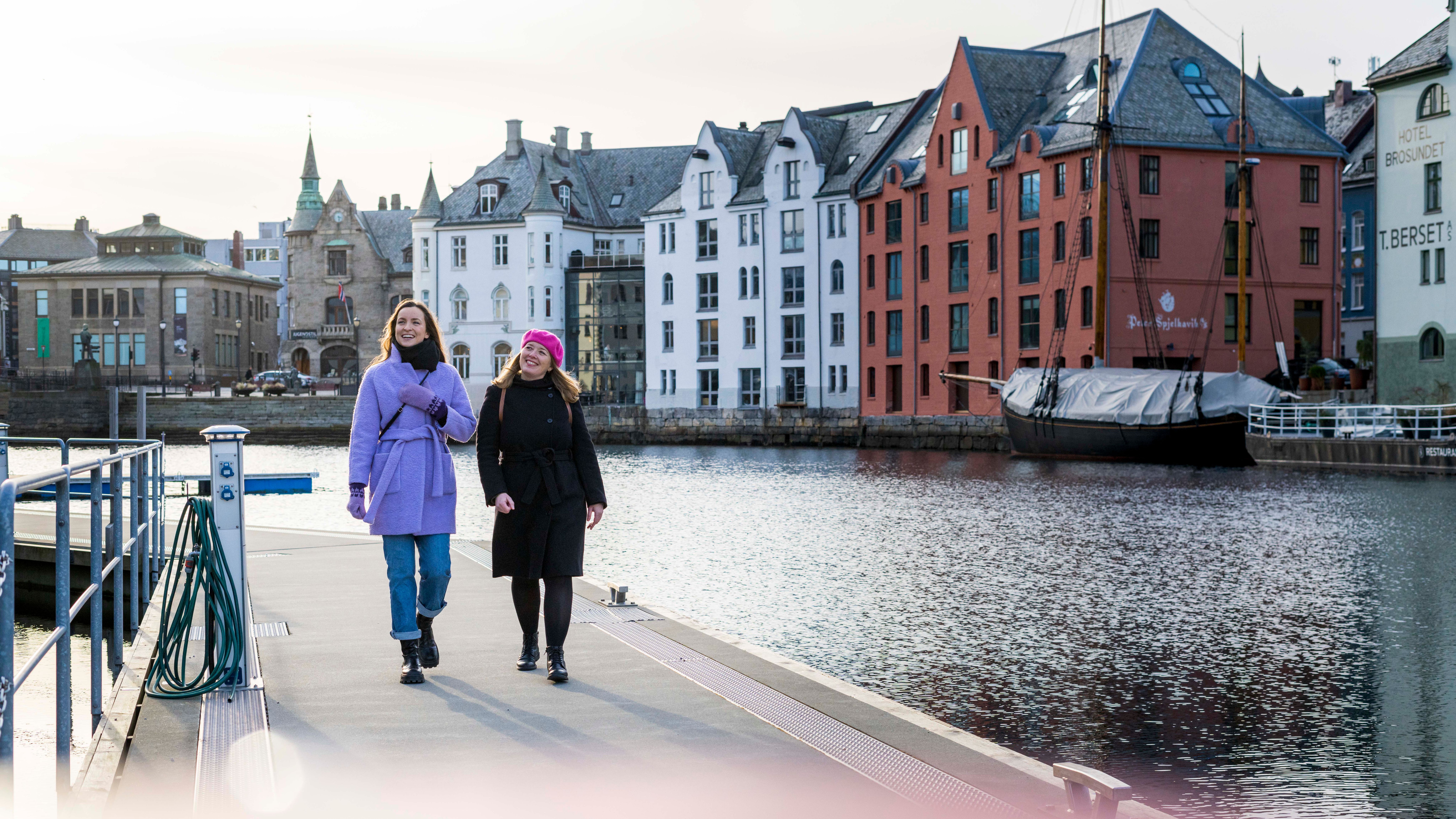 Two women walking along the Brosundet strait in the art noveau city Ålesund
