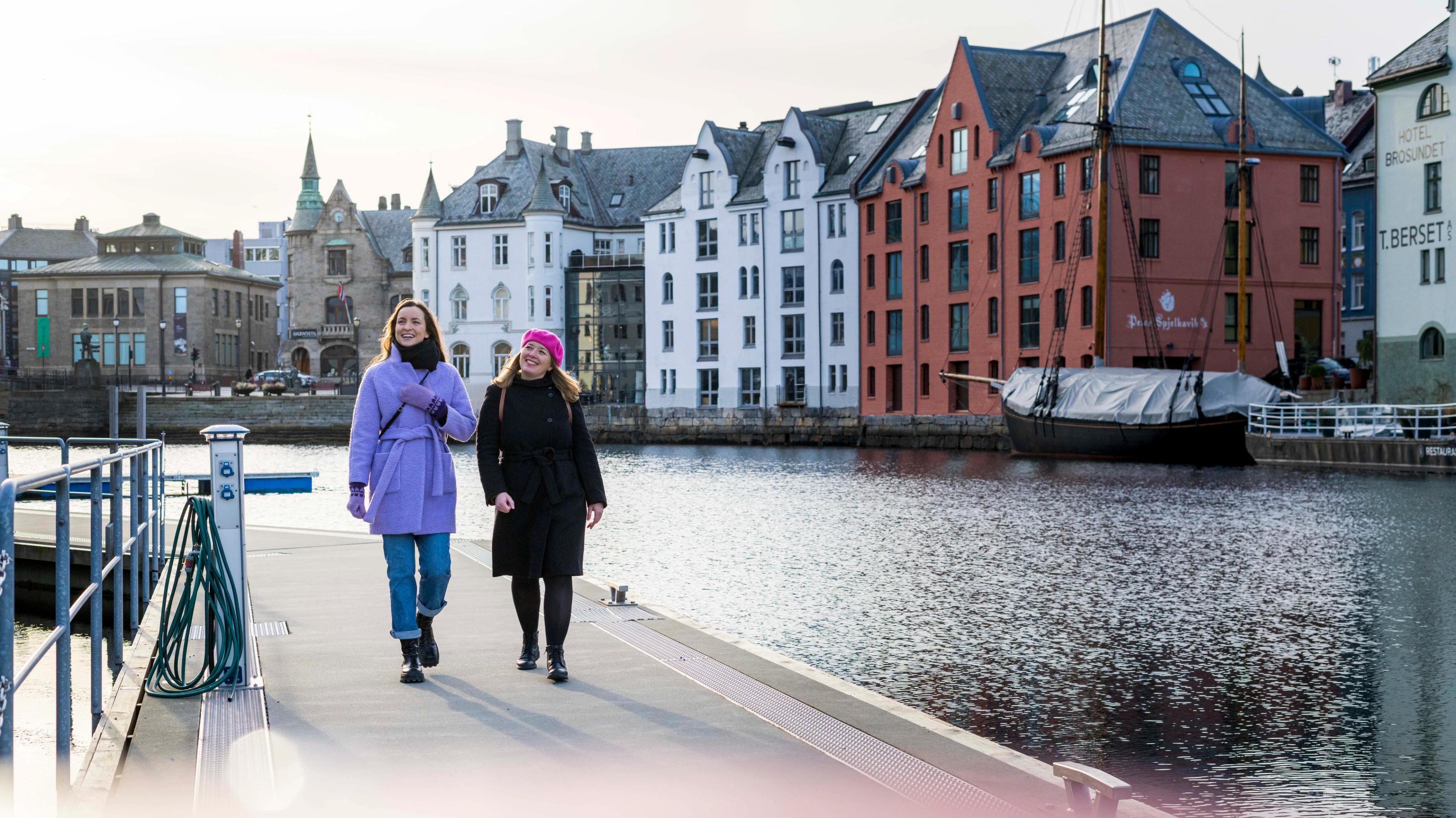Two women walking along the Brosundet strait in the art noveau city Ålesund