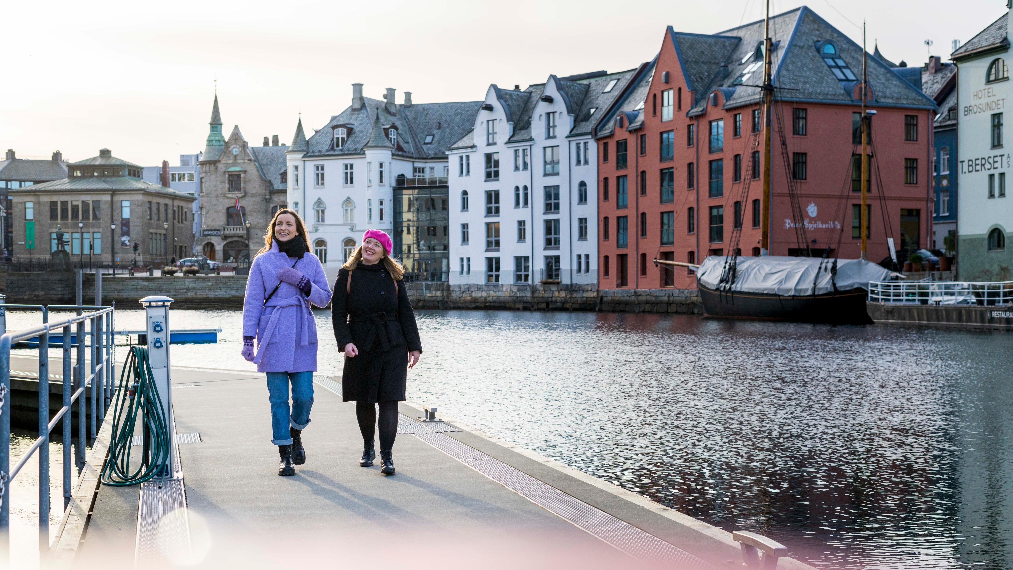 Two women walking along the Brosundet strait in the art noveau city Ålesund