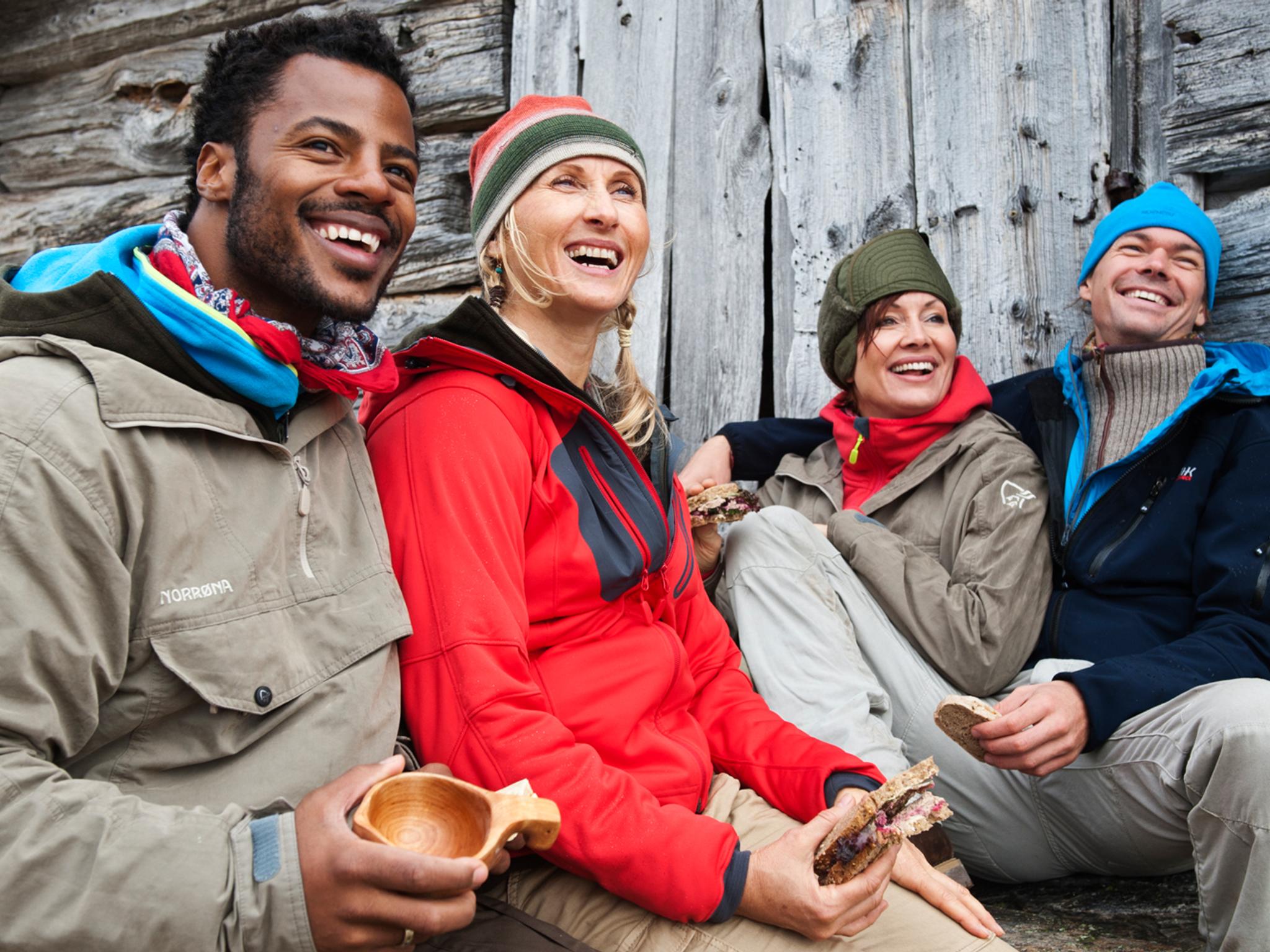 Four people resting outside of a mountain cabin in Beitostølen, Norway