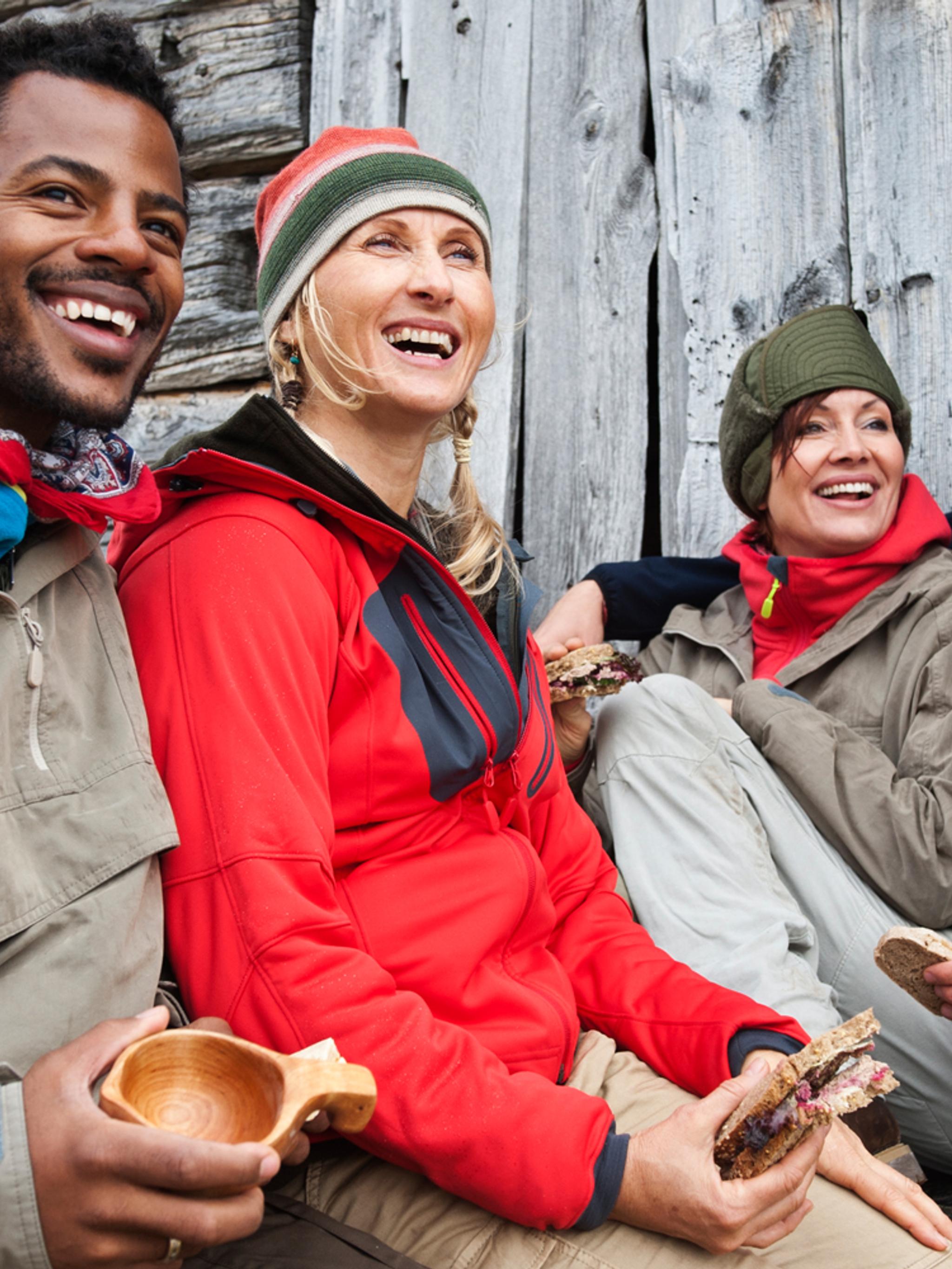 Four people resting outside of a mountain cabin in Beitostølen, Norway