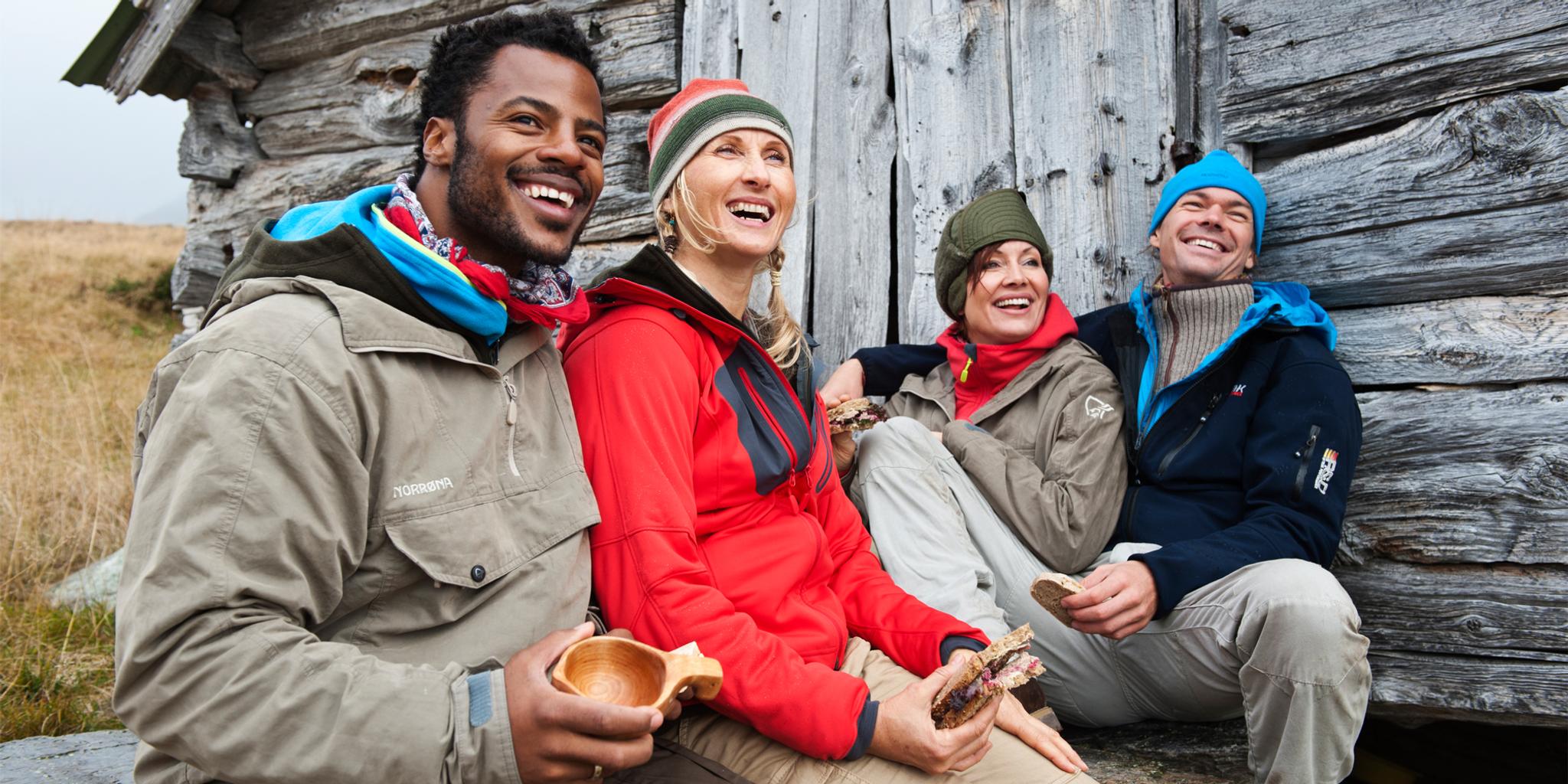 Four happy people sitting outside a mountain cabin in Beitostølen, Eastern Norway