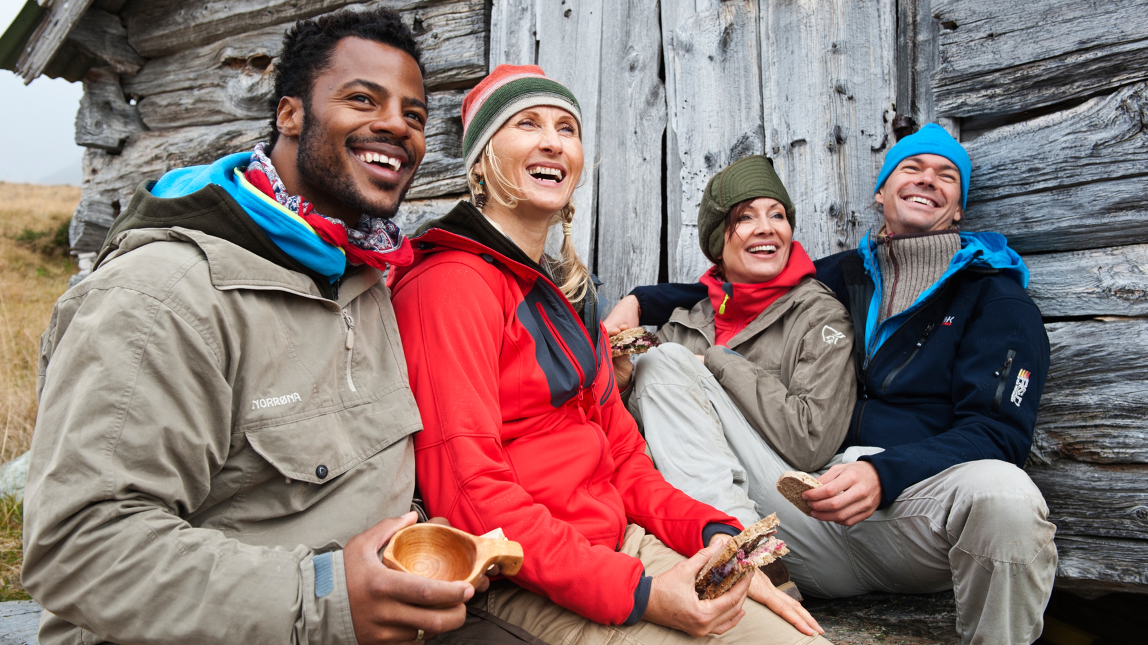 Four people resting outside of a mountain cabin in Beitostølen, Norway