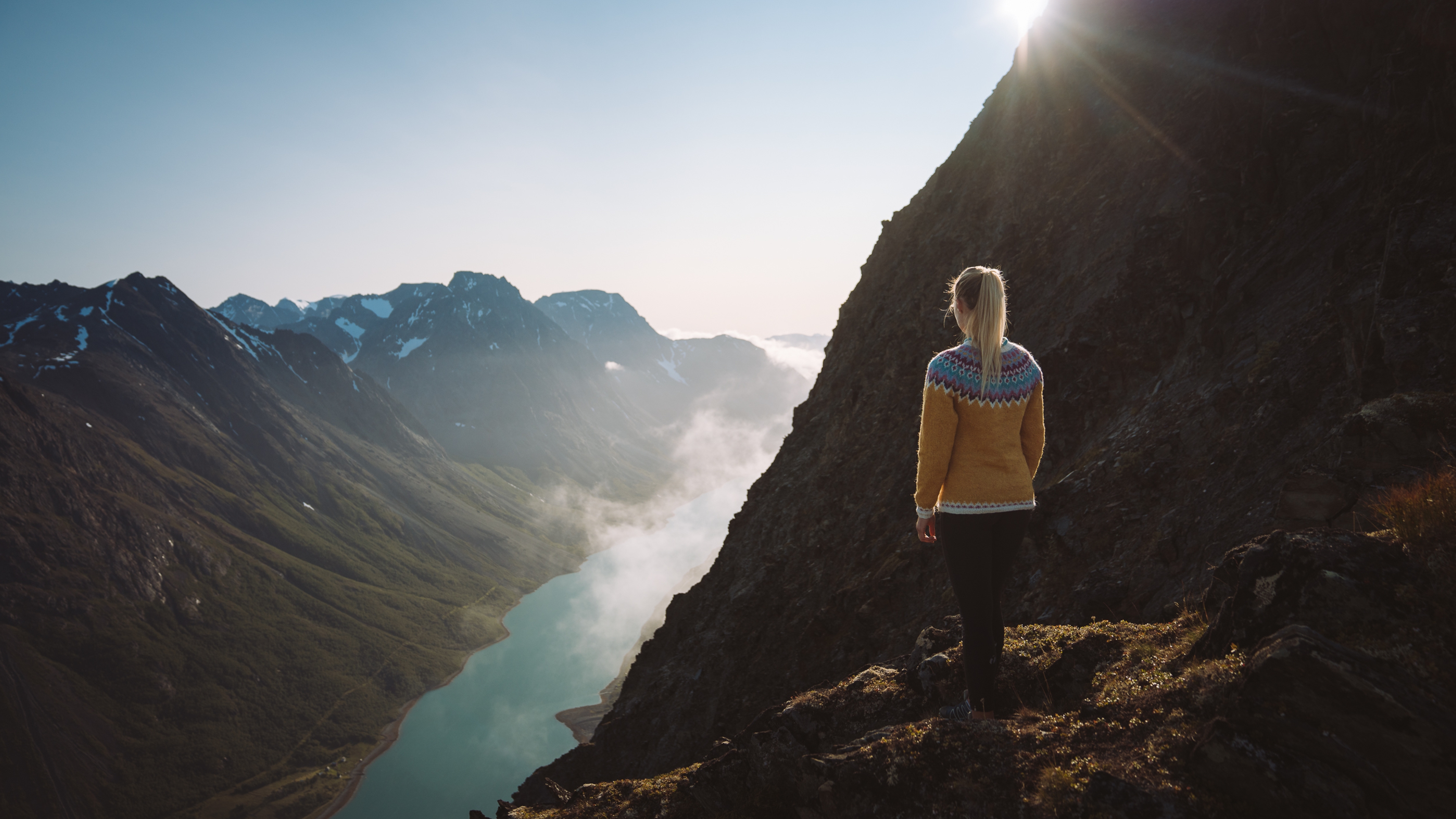 A woman is admiring the fjord view on a hike in Tromsø, Northern Norway