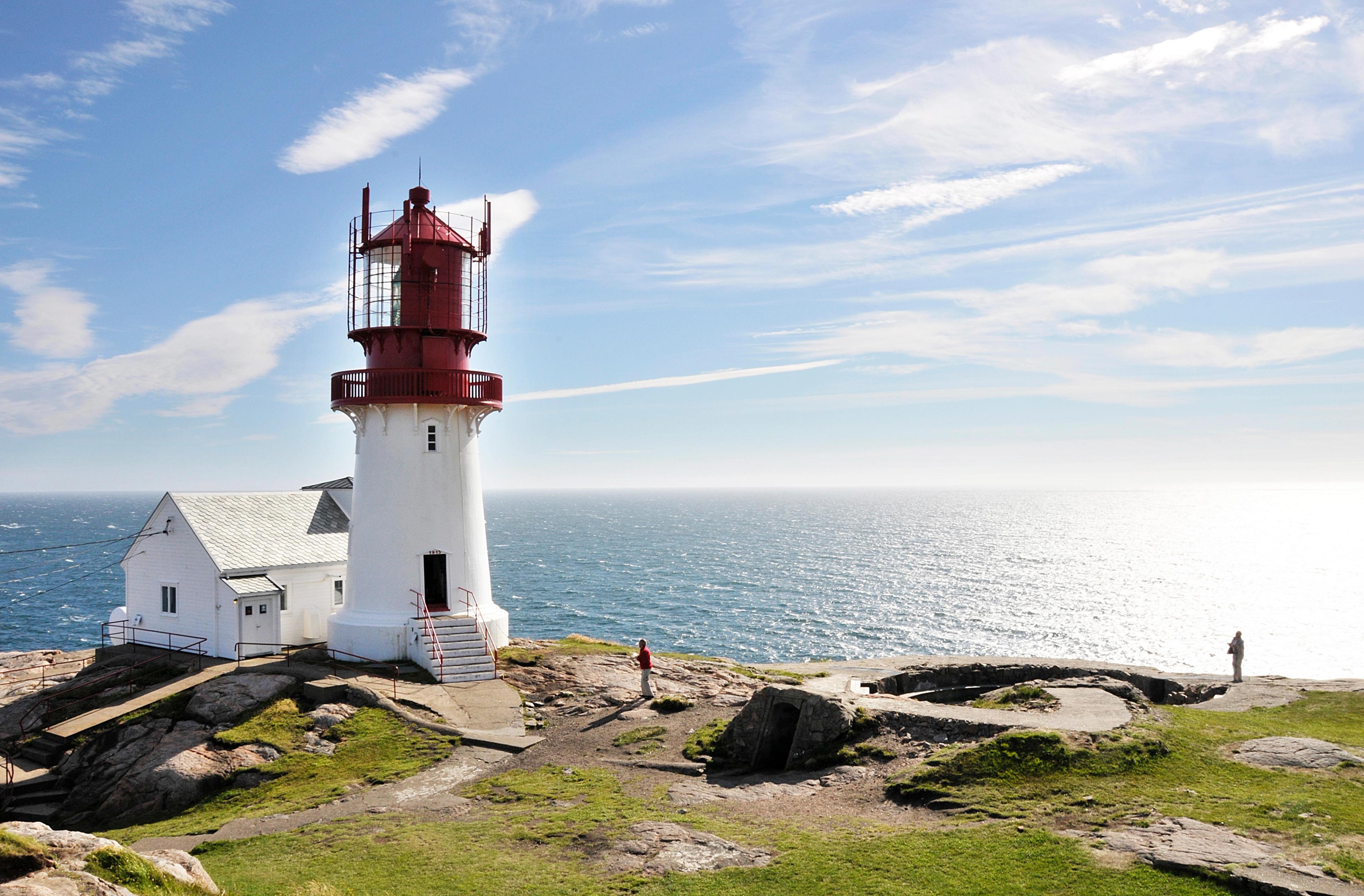 The white and red Lindesnes lighthouse in sunshine, on the coast of Lindesnes in Southern Norway