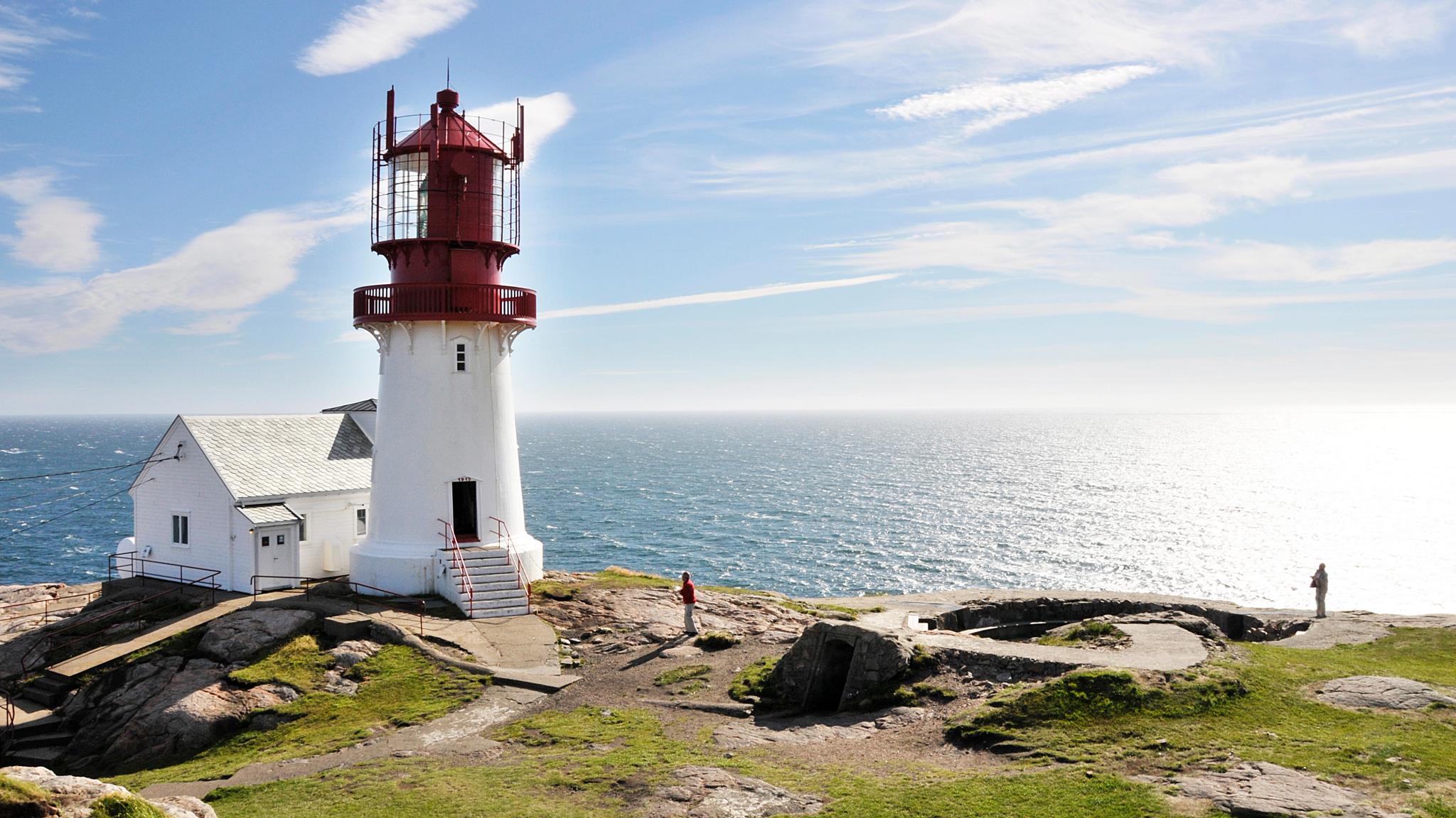The white and red Lindesnes lighthouse in sunshine, on the coast of Lindesnes in Southern Norway