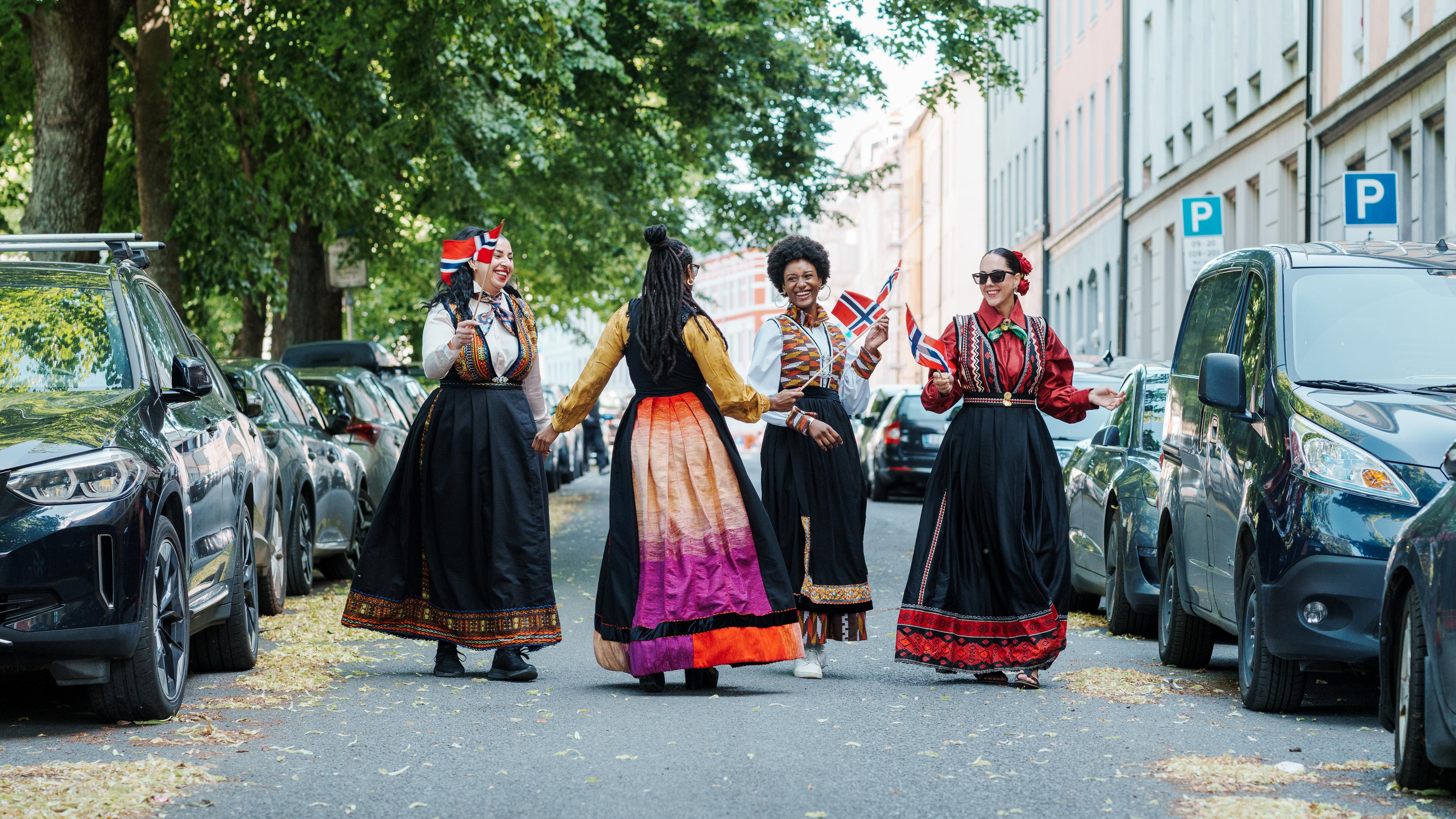 Fire damer i fargerike festdrakter