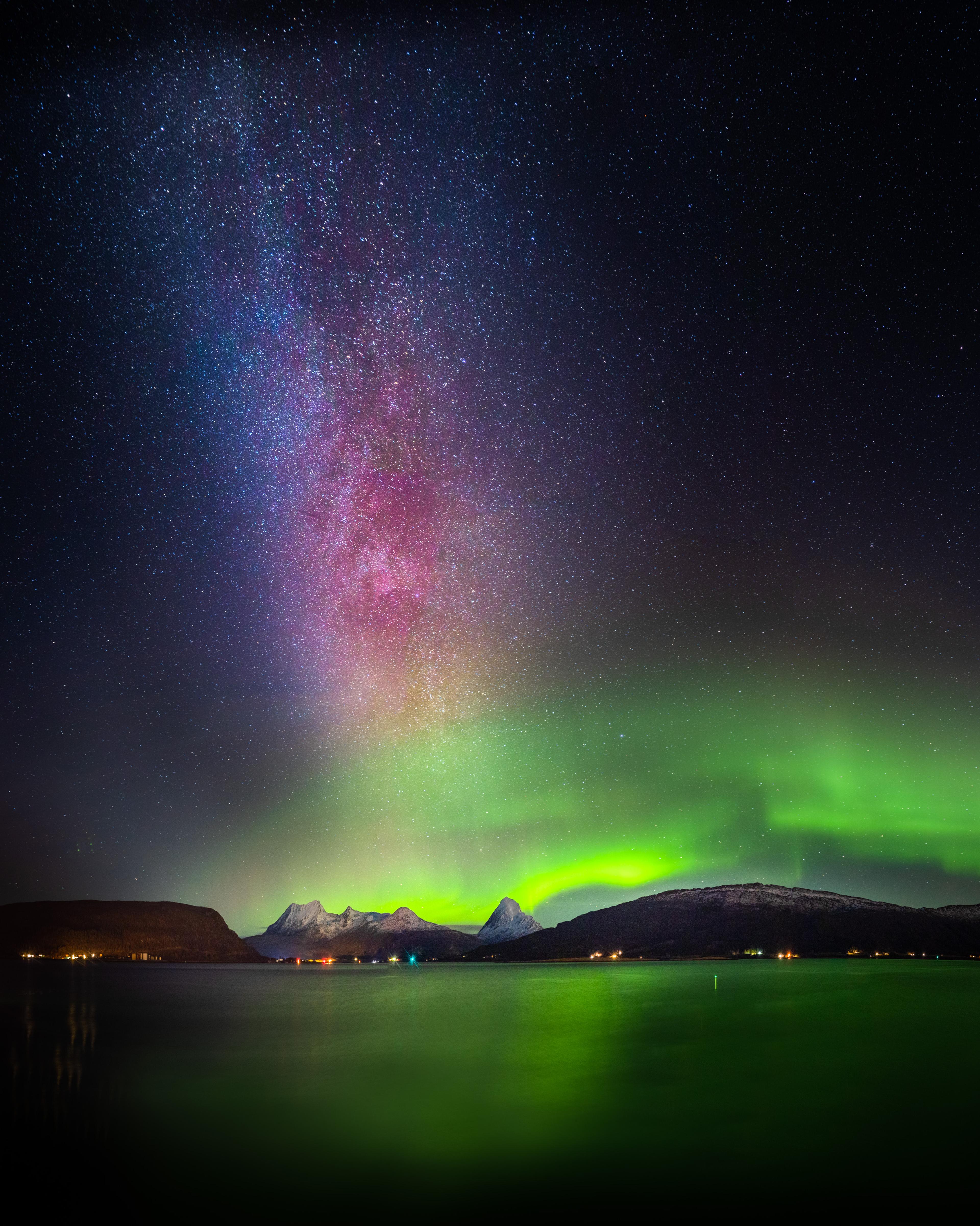 Northern lights and a starry sky over mountains.