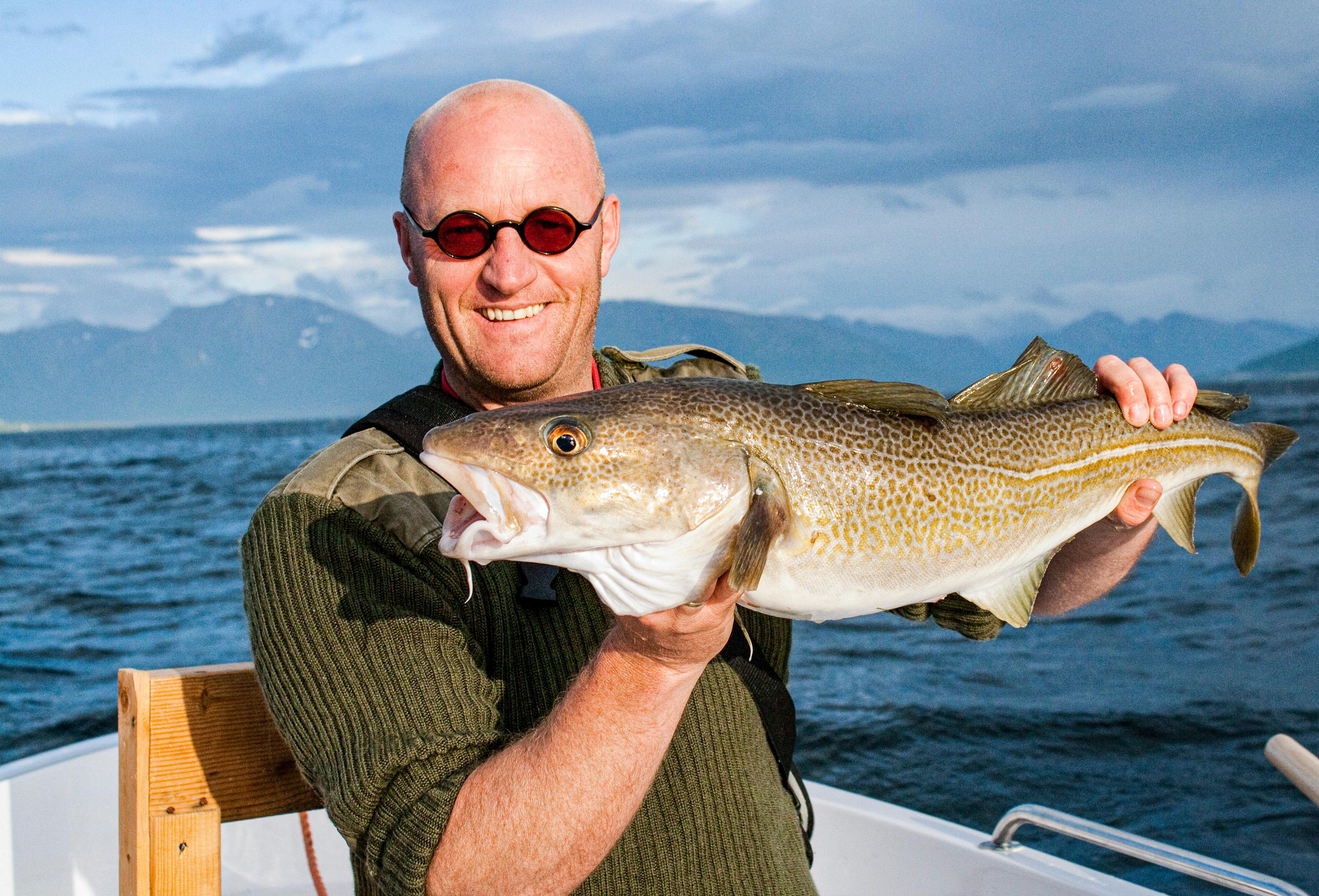 Man showing off his catch of the day on a fishing trip in Vesterålen, Northern Norway