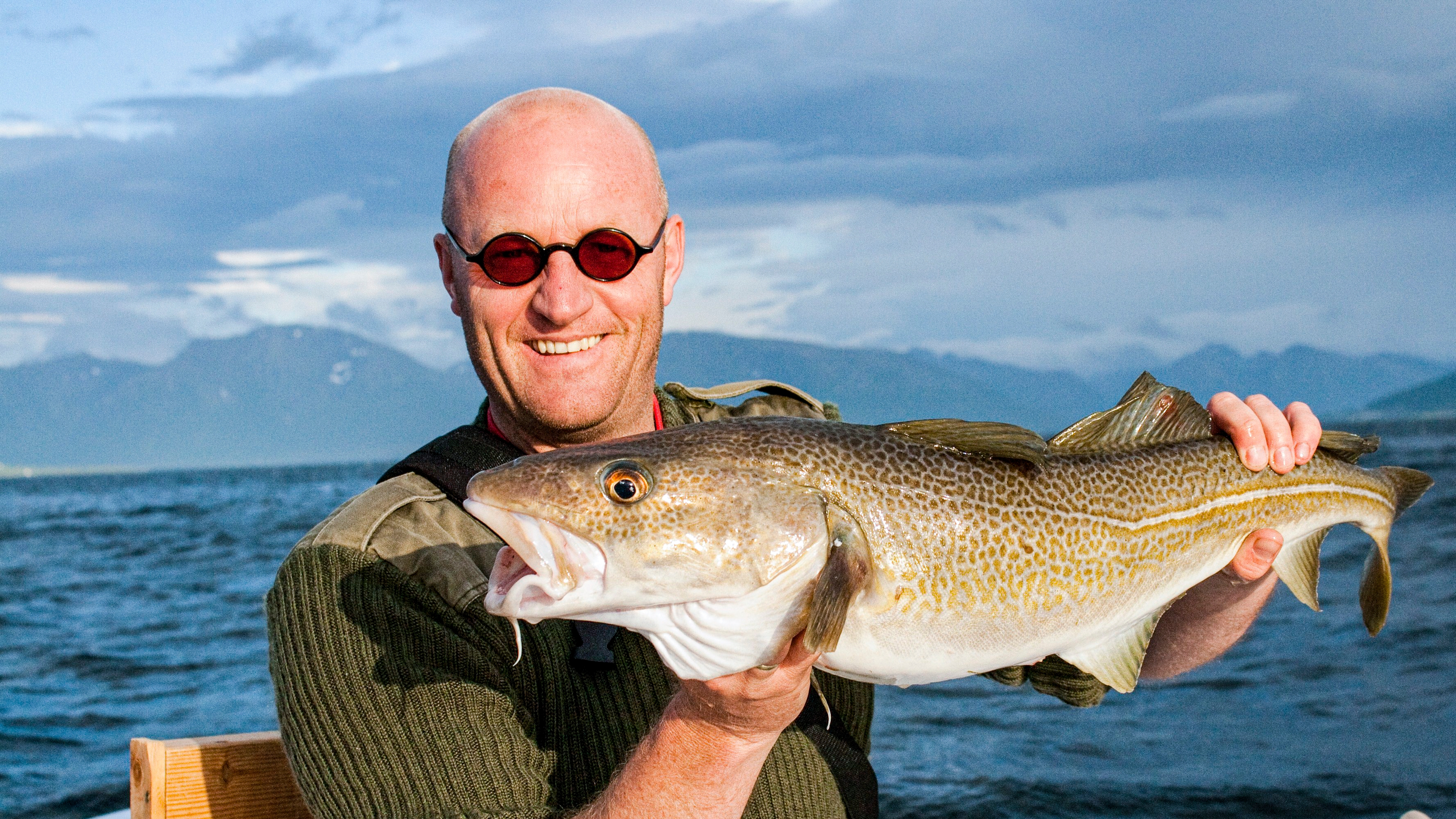 Man showing off his catch of the day on a fishing trip in Vesterålen, Northern Norway