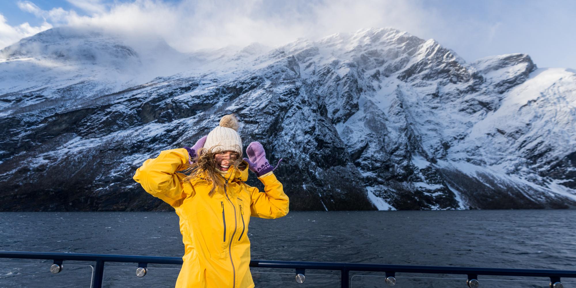 Woman on top of the sightseeing boat from Ålesund to the Geirangerfjord in winter