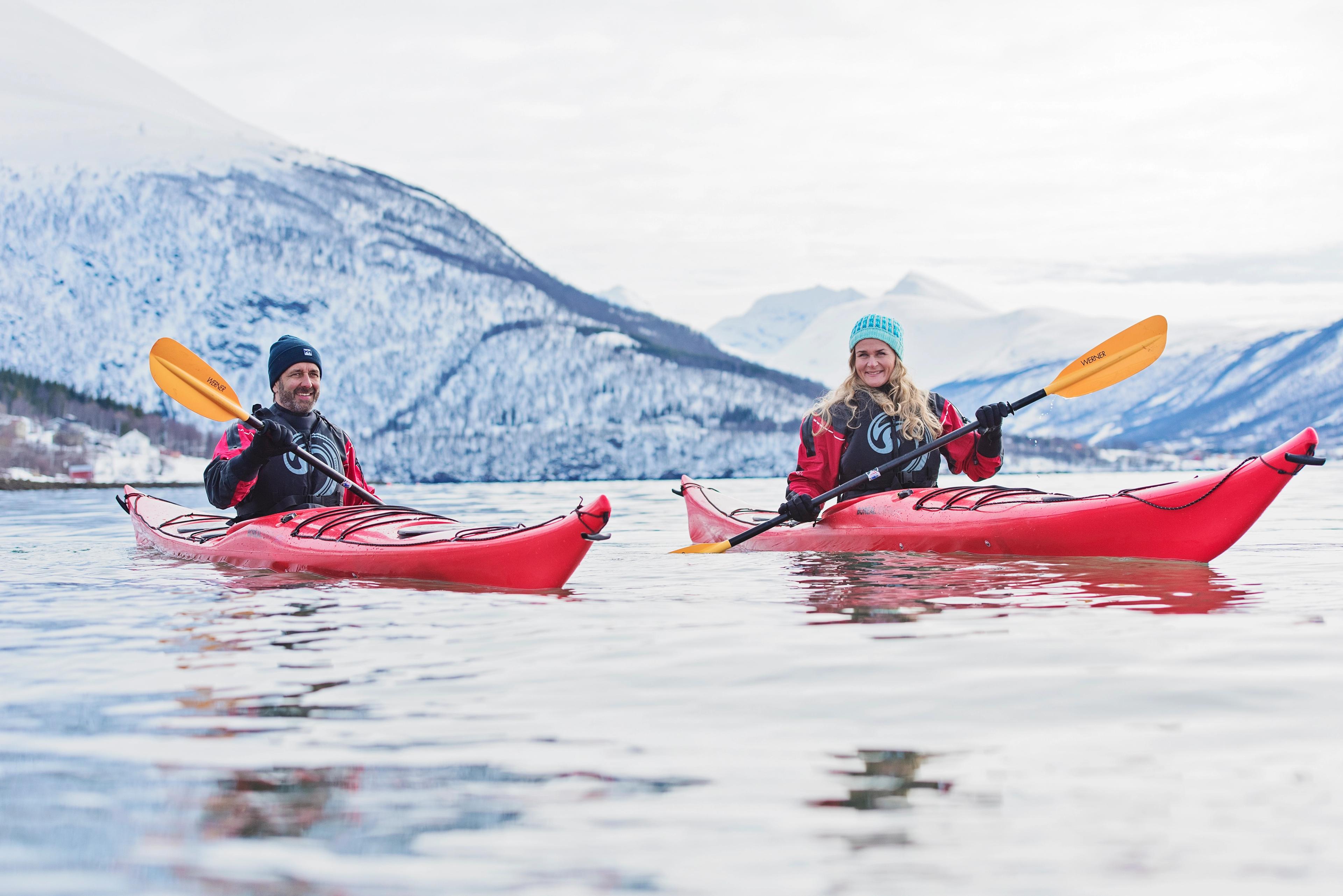 Two people on a Hurtigruten coastal expedition kayaking in the winter in Norway