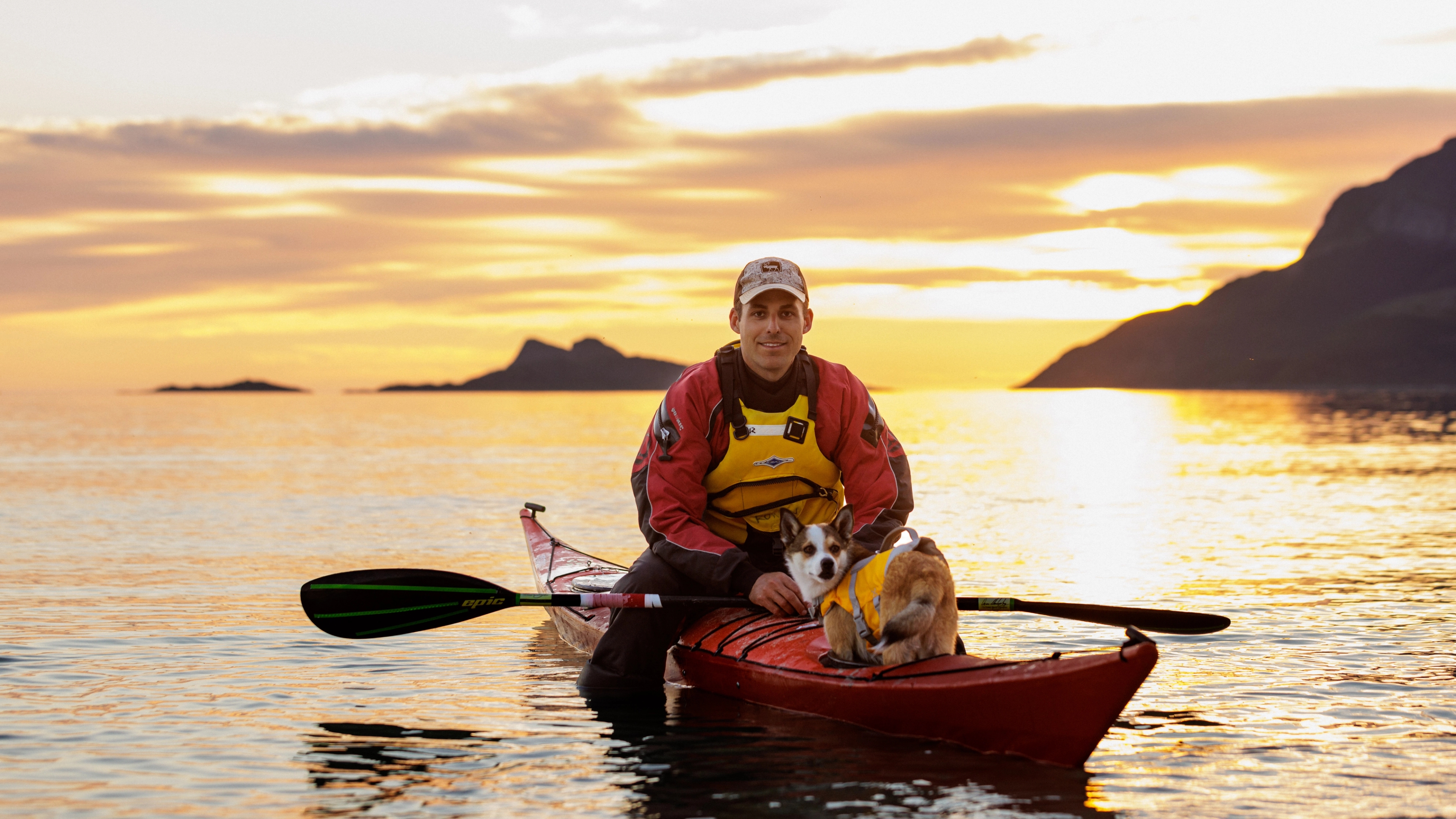 A man kayaking with his dog in the midnight sun at Kvaløya, Tromsø