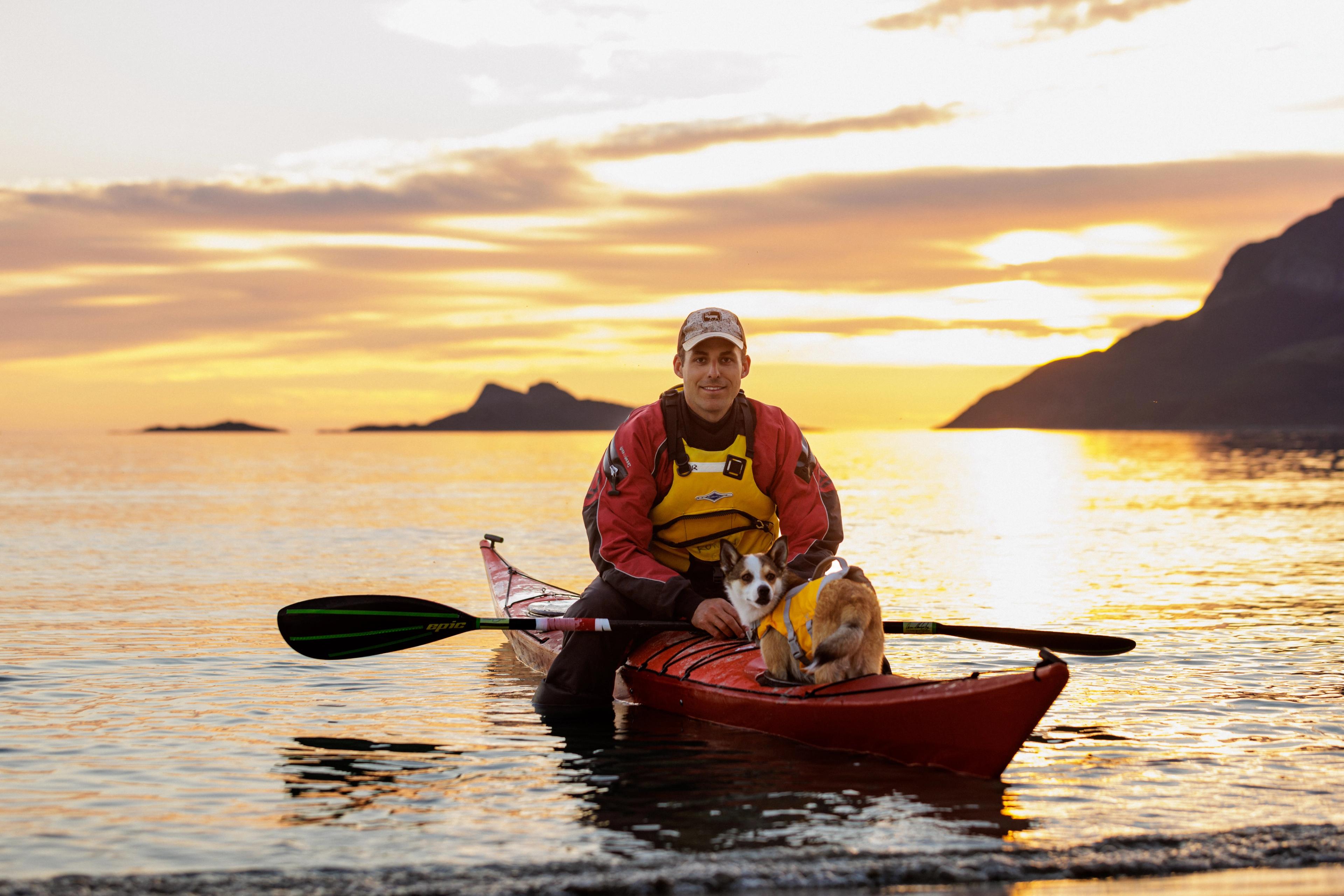 A man kayaking with his dog in the midnight sun at Kvaløya, Tromsø
