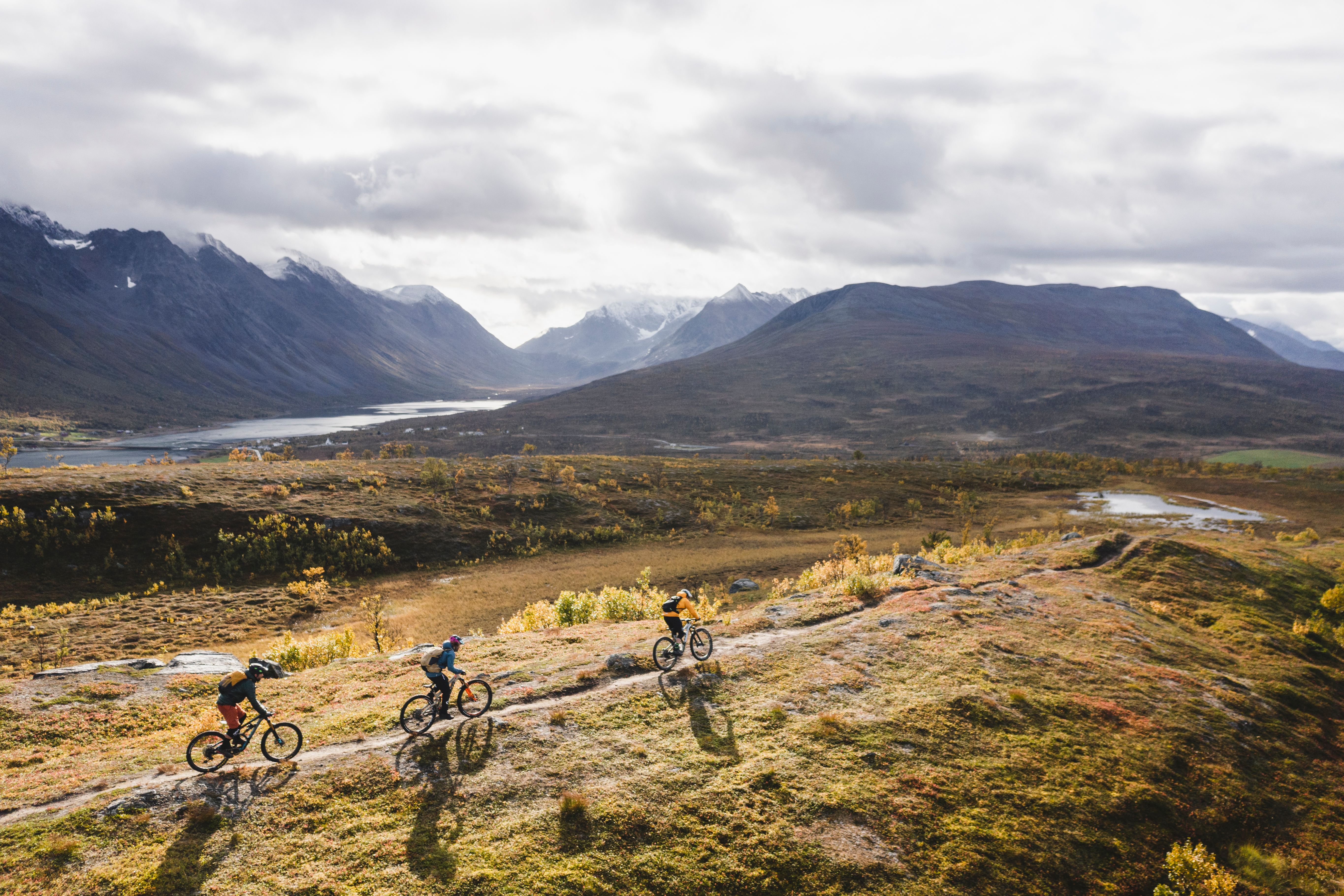 Tre personer på MTB i bergen i Lyngenfjord, norra Norge