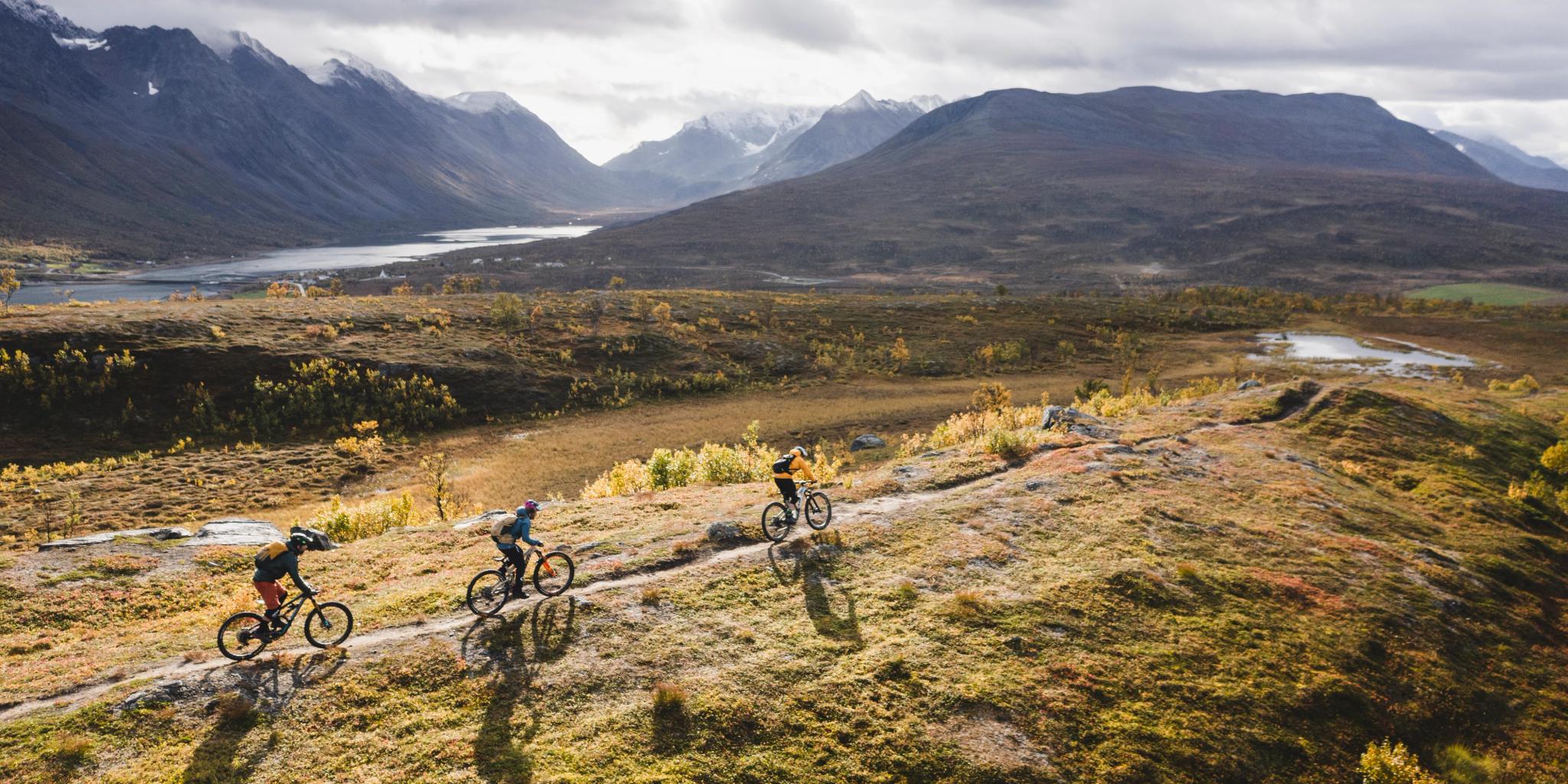 Tre personer på MTB i bergen i Lyngenfjord, norra Norge